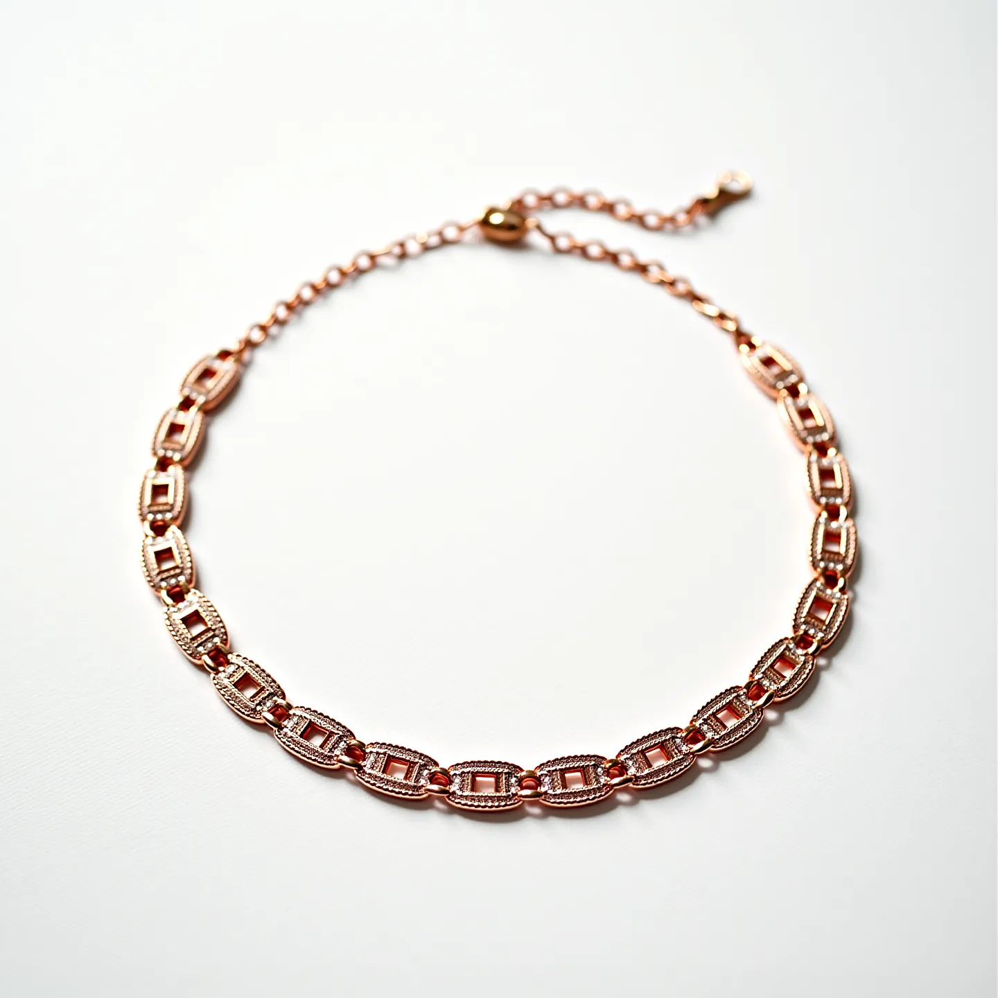 This choker chain is crafted from rose gold-toned metal, featuring an elegant series of interlocking links with a geometric design. The chain is composed of polished, oval-shaped elements that are accented with intricate detailing along their edges, adding a layer of sophistication to the overall piece. At the end of the choker, a simple, yet functional, lobster clasp ensures secure attachment and ease of use. The length of the choker can be adjusted with the attached extender chain, allowing for a customizable fit. The craftsmanship highlights a modern aesthetic while maintaining a classic allure, suitable for various occasions.