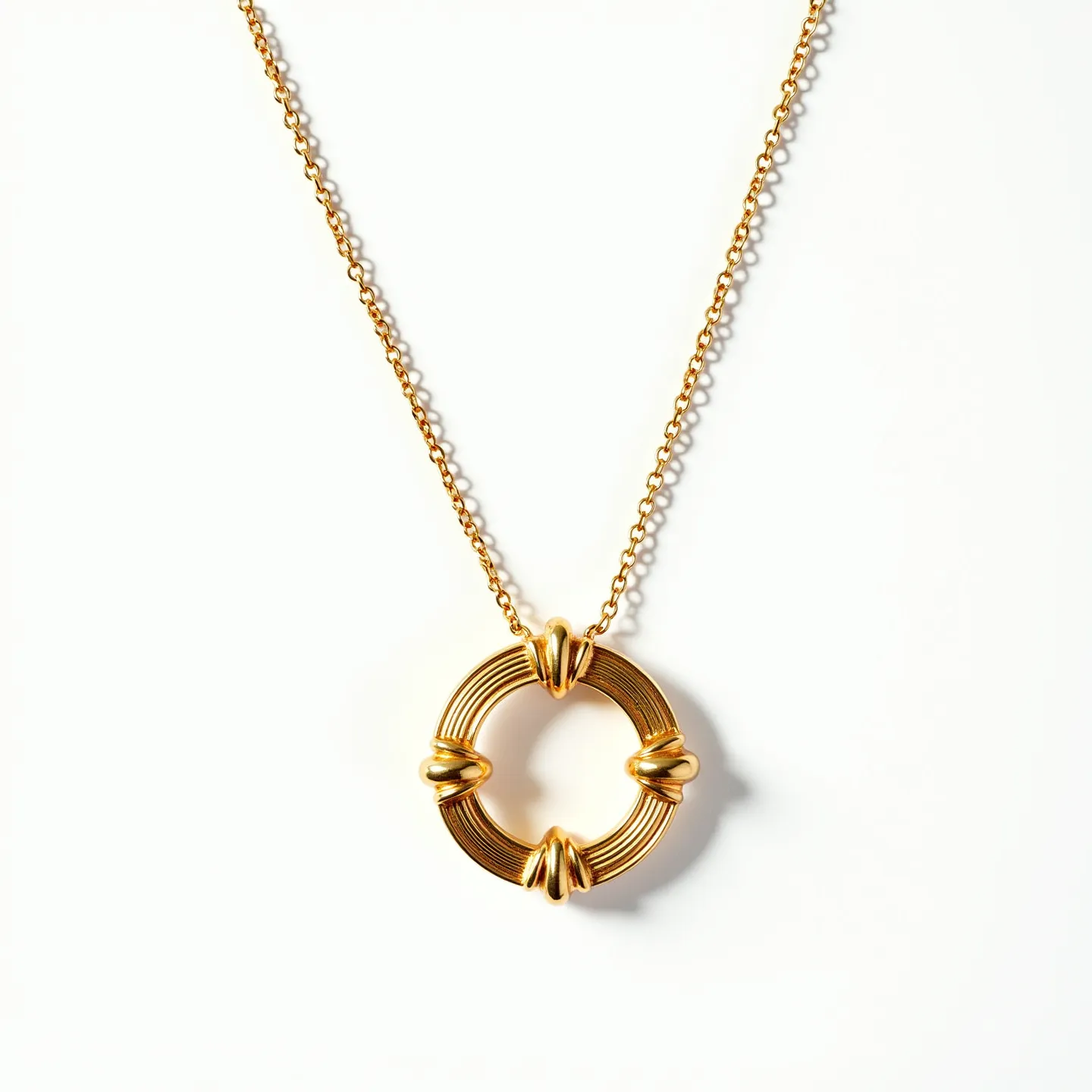 This circle necklace features a prominently gold-toned circular pendant designed with multiple concentric ridges, creating a textured and elegant appearance. It is accented at four equidistant points with smooth gold bands that enhance its visual interest and provide a dynamic design element. The chain is composed of small interlocking links, also gold-toned, complementing the pendant's color and style. The necklace likely includes a standard clasp for secure fastening, although the specifics of the clasp are not visible. The intricate detailing and lustrous finish highlight the craftsmanship and artistic design of the piece.