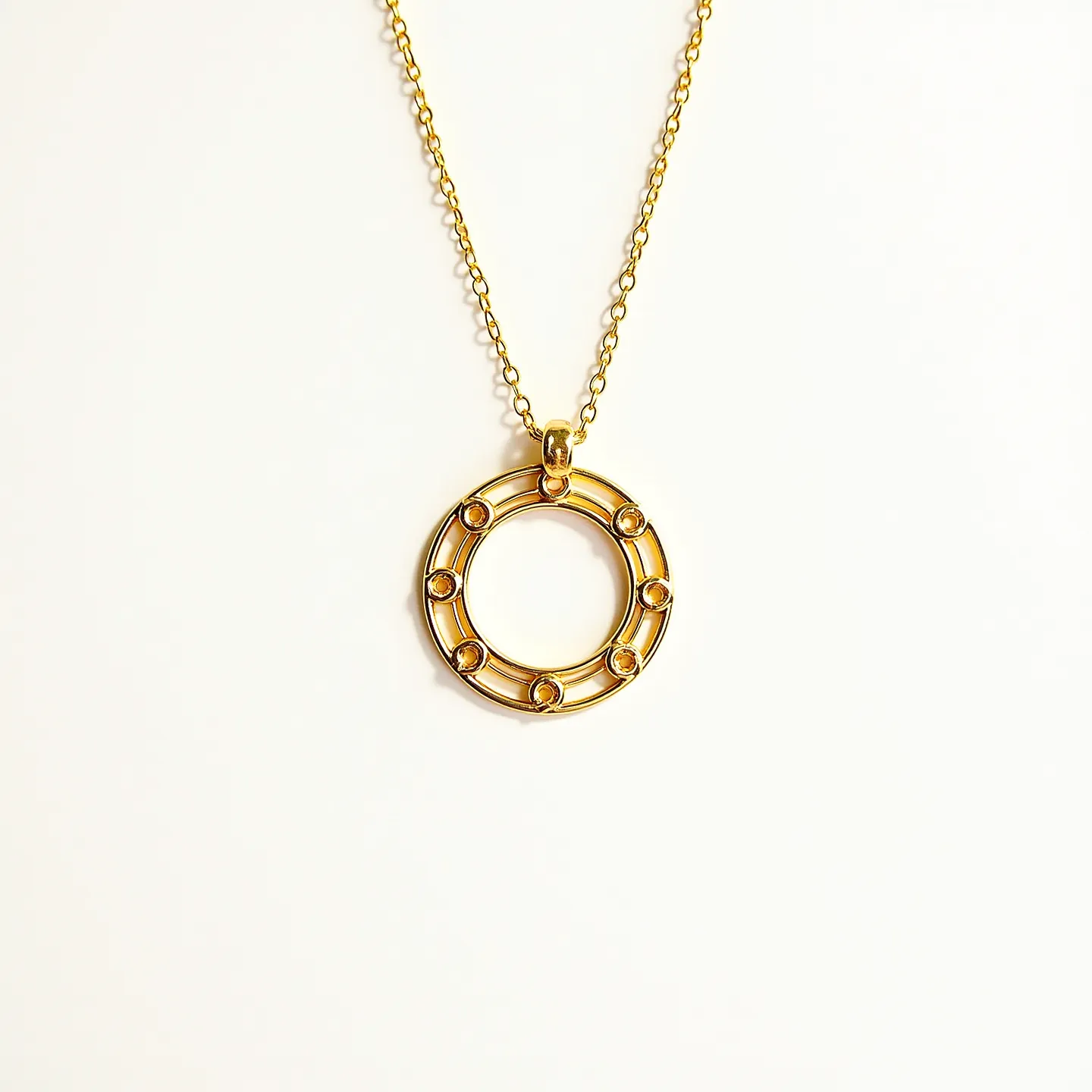 This circle necklace features an elegant gold-toned circular pendant with seven small round-cut gems, each skillfully set in a bezel setting that ensures they are securely held in place. The pendant's open design is both modern and timeless, allowing each stone to catch the light beautifully. It hangs from a delicate gold-toned chain with evenly spaced links that add to its refined aesthetic. The necklace includes a simple yet secure clasp attachment, ensuring ease of wear and a polished finish.