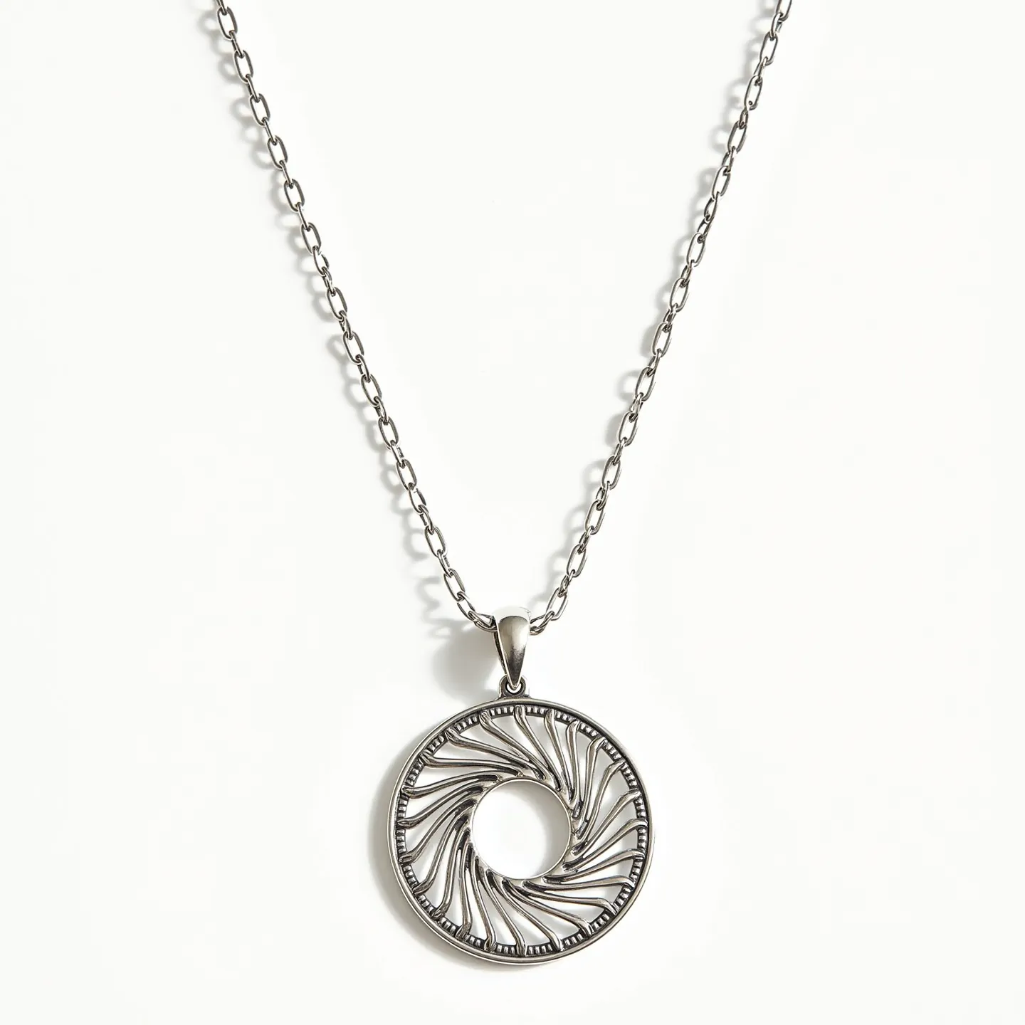 This circle necklace features an intricately designed pendant with an open circular pattern that seems to mimic a swirling motion. The pendant is crafted from a metallic material, likely silver or a similar metal, with a polished finish that accentuates its elegant curves. The design is further enhanced by a delicate chain that complements the pendant's metallic sheen. The pendant is attached to the chain with a simple yet secure bail, contributing to its streamlined and sophisticated appearance. The overall design of the necklace is elegant and modern, making it a versatile accessory for various occasions.