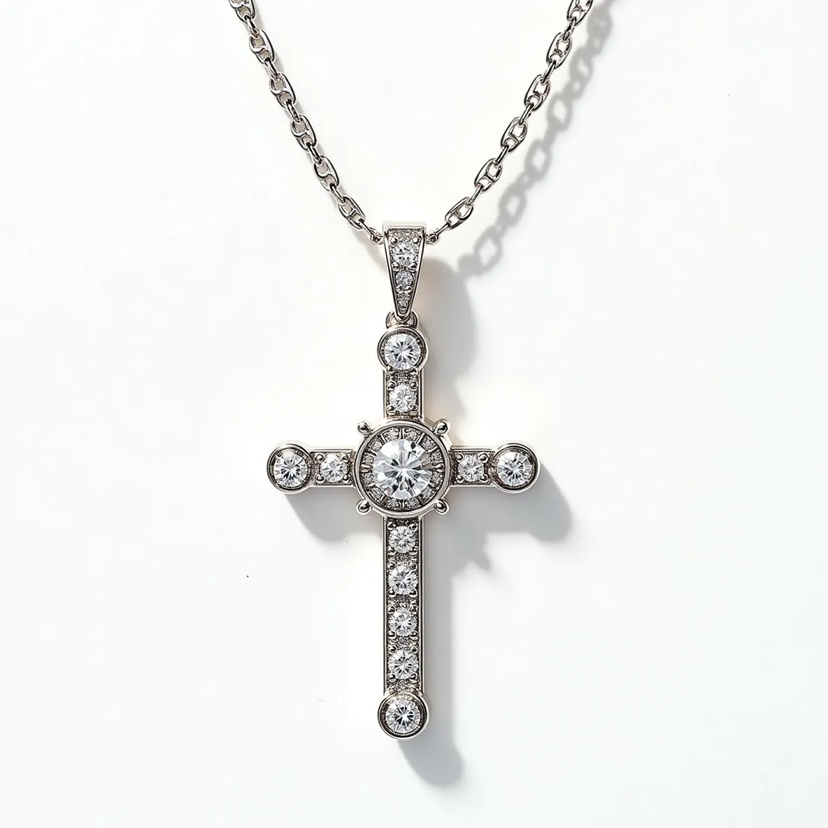 This cross diamond necklace features a beautifully crafted design with a central round-cut diamond as its focal point, surrounded by smaller round diamonds along the arms of the cross. Each arm of the cross is accented with equally spaced diamonds, all set in a pavé style, enhancing the necklace’s dazzling appearance. The setting appears to be made of white gold or platinum, giving a luxurious backdrop to the sparkling gems. The pendant hangs from a delicate chain, which is likely made of the same metal, and attaches with a simple yet elegant bail encrusted with additional diamonds, seamlessly integrating it into the overall design.