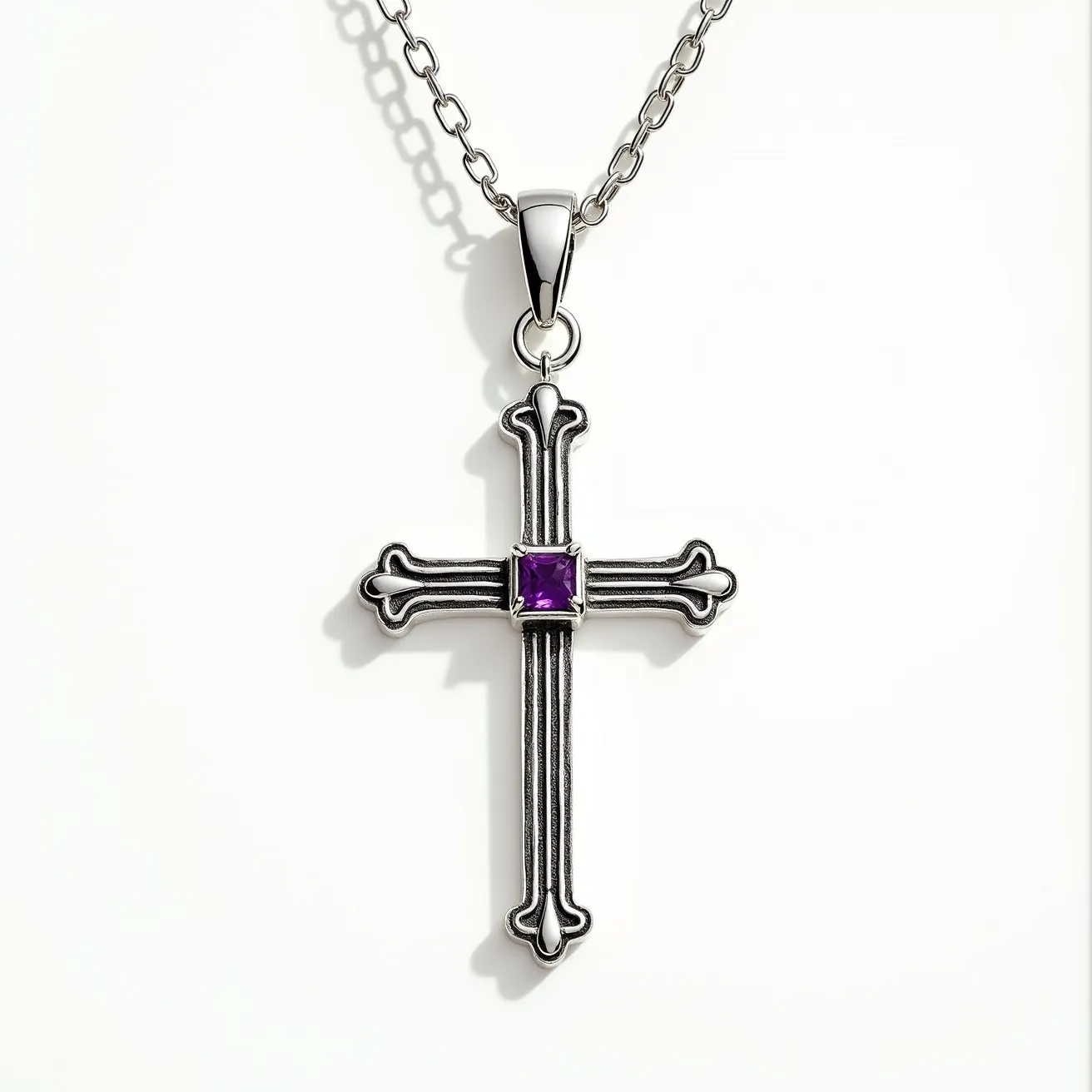 This cross necklace features a detailed design crafted in what appears to be a silver-toned metal, showcasing a graceful, ornamental pattern at each end of the cross. At the center of the cross is a square-cut, vibrant purple gemstone set in a bezel setting, adding a pop of color and elegance to the piece. The necklace is attached to a chain with a polished bail that facilitates smooth movement along the chain. The chain itself consists of interlocking links, providing both durability and a classic appearance.