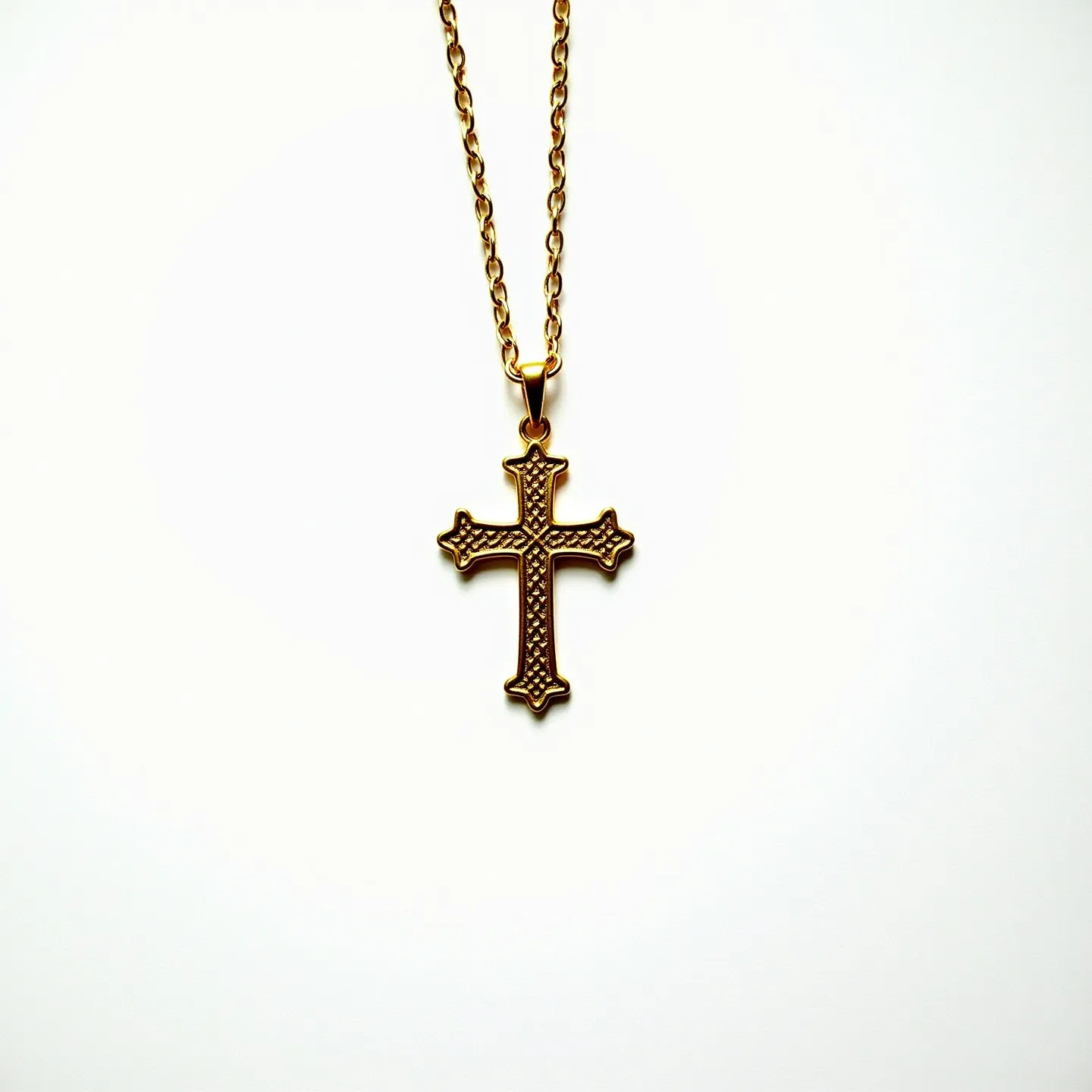 This cross necklace features a gold-tone metal cross pendant with intricate textured detailing on its surface, creating a visually captivating design. The pendant has an elegant silhouette with rounded edges at each point of the cross, adding a touch of sophistication to its classic form. The chain is composed of matching gold-tone links, providing a cohesive appearance. It is attached to the pendant via a simple bail, ensuring the pendant hangs gracefully. The necklace is secured with a standard spring ring clasp, offering both functionality and ease of use.