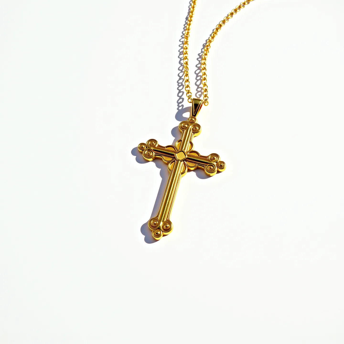 This cross necklace features a finely crafted design in what appears to be gold, showcasing intricate detailing with a layered and ornate pattern. The cross is adorned with decorative elements that give it a rich and luxurious appearance. The necklace includes a simple chain that complements the pendant, likely made from the same material for a cohesive look. The attachment includes a classic bail through which the chain passes, allowing the cross to hang elegantly. The polished finish of the necklace adds to its allure and sophistication.