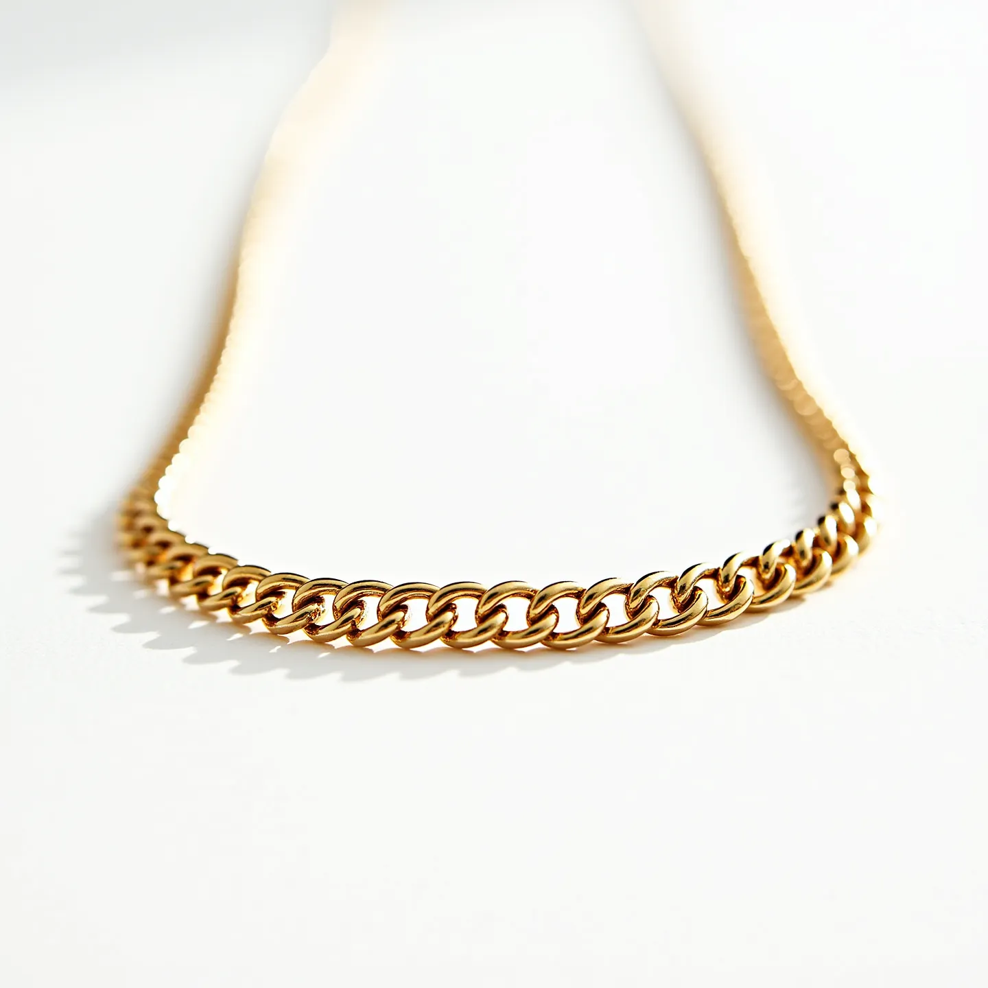 This Cuban link chain is crafted from a polished gold material, characterized by closely interlocking links that form a continuous pattern, giving it a classic and elegant appearance. The chain exhibits a smooth and reflective surface, highlighting the high-quality finish often associated with gold jewelry. The design is simple yet bold, offering versatility as both a standalone piece or layered with other necklaces. The clasp or attachment is not visible in this image, but Cuban link chains typically feature a secure clasp to ensure durability and ease of wear.