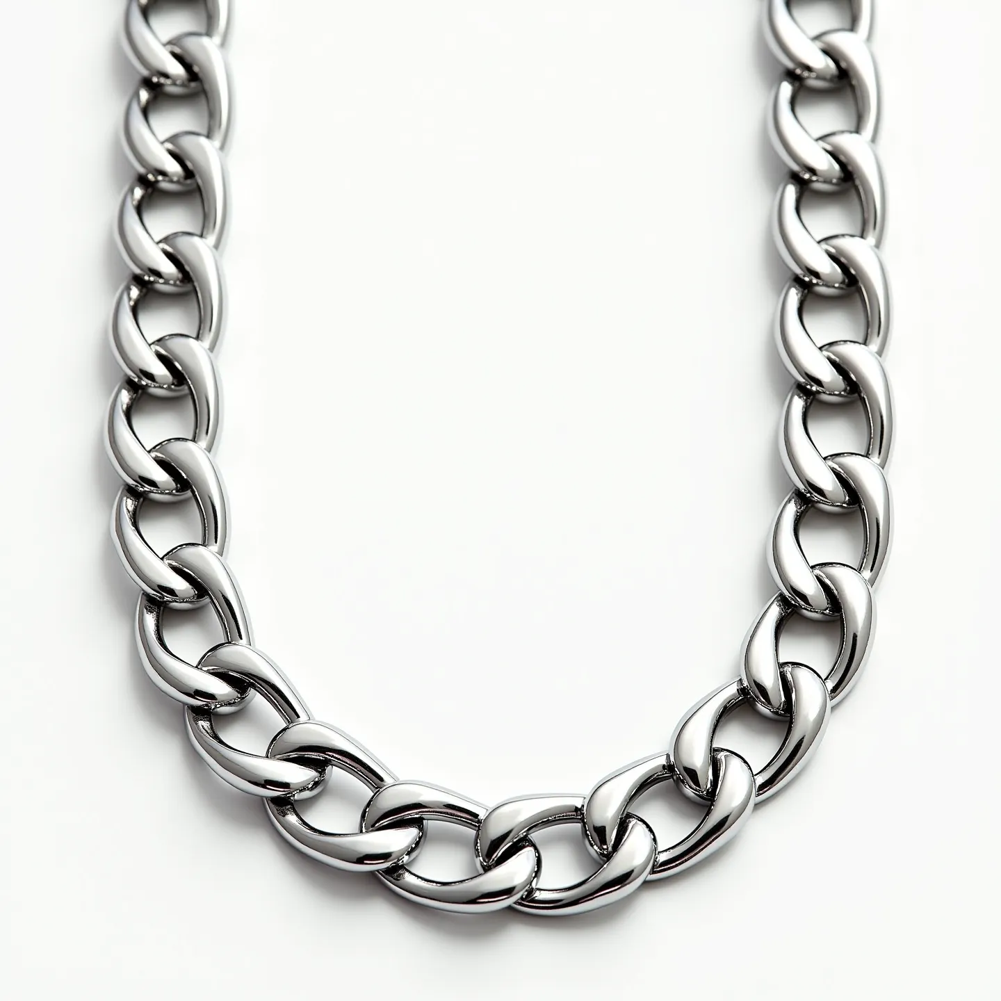 This Cuban link chain is crafted from a polished silver-colored metal, showcasing tightly interlocking links that create a smooth, fluid appearance. The chain is sleek and substantial, emphasizing its high-quality craftsmanship. There are no visible stones or gems embedded within the design, which highlights the seamless, uninterrupted flow of the links. The clasp or attachment, if present, is not visible in this image, allowing the focus to remain on the chain's elegant and timeless form.