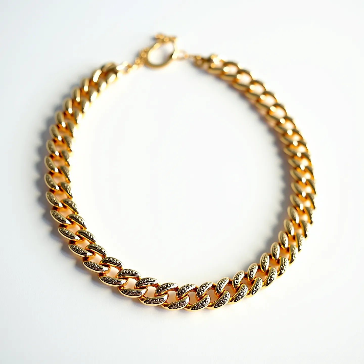 This Cuban link chain is crafted from a gold-toned metal, showcasing the classic interlocking pattern that defines its bold aesthetic. Each link is adorned with small, round-cut gems that are set in a pave setting, adding a touch of sophistication and sparkle. The necklace is secured with a lobster clasp, providing a reliable and stylish closure that complements its overall elegant design.