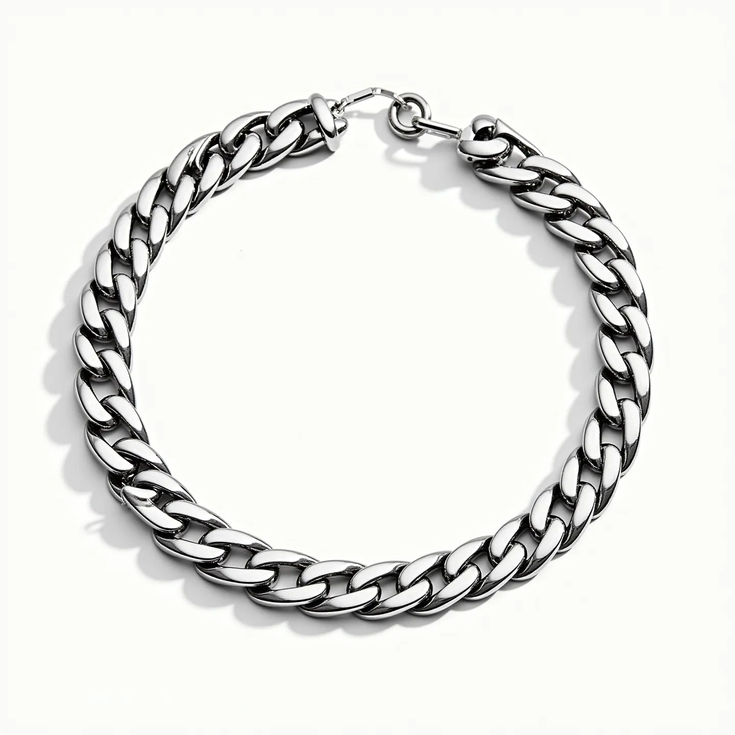 This curb chain is crafted from a polished metal, likely stainless steel or silver, giving it a sleek and shiny appearance. The chain exhibits a series of interlocking, flat, and uniformly shaped links, providing it with a classic curb chain style. The chain is equipped with a lobster clasp, which is a popular and secure type of closure, ensuring ease of wear and reliability. There are no visible gems or stones embedded within this piece, maintaining its simple and elegant design.