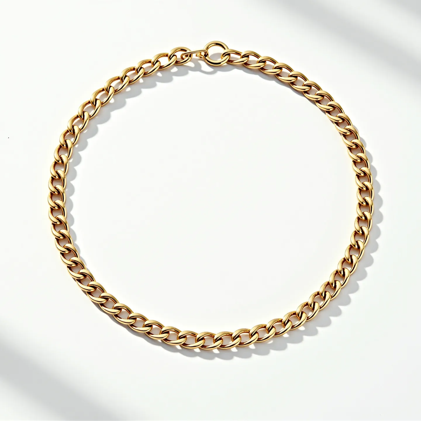 This curb chain features a classic design with interlocking flat, oval-shaped links crafted from a polished yellow gold material, giving it a shiny and lustrous appearance. The chain is secured with a round spring ring clasp for easy wearability. There are no visible gemstones or additional adornments, emphasizing the chain's simple yet elegant design. The links are uniformly sized, contributing to a balanced and symmetrical look that suits a variety of styles and occasions.