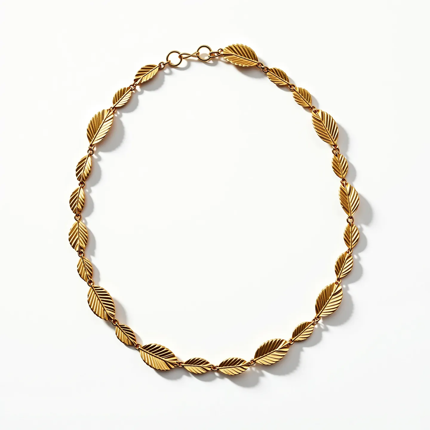 This curb chain features a series of interconnected, gold-toned leaf-shaped links that create an elegant and cohesive pattern. The leaf design adds a natural and sophisticated touch, enhancing the aesthetic appeal of the accessory. The chain is secured with a simple hook clasp, ensuring both functionality and ease of wear. The craftsmanship suggests a focus on design continuity, with each leaf contributing to the overall fluidity and charm of the piece.