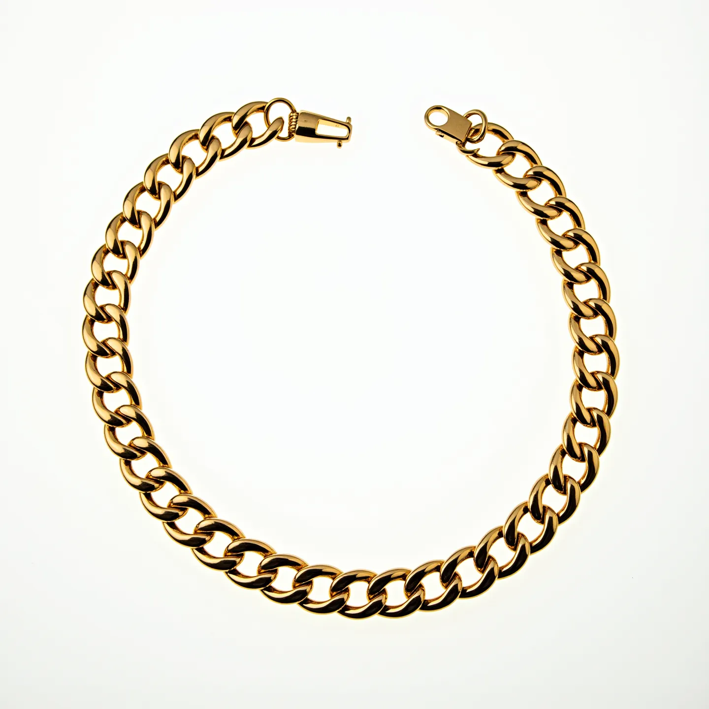 This curb chain is crafted from a polished gold-toned metal, featuring a series of interlocking flat links that create a sleek and fluid design. The chain is equipped with a secure clasp, designed to seamlessly blend with the overall aesthetic. The clasp appears to be a typical lobster style, providing both functionality and a neat finish to the piece. There are no visible gemstones or additional embellishments, allowing the chain's inherent elegance to be the focal point.