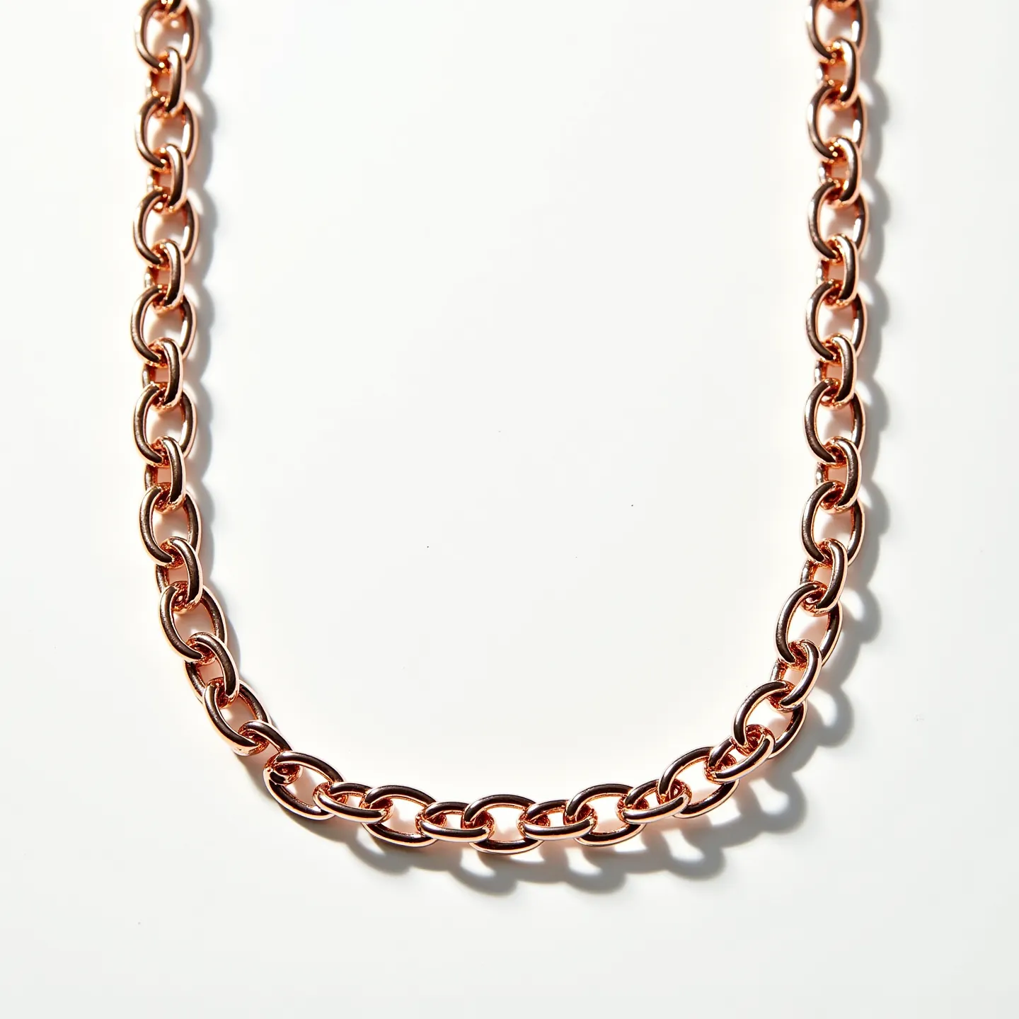 This curb chain is crafted from a material with a rose gold finish, giving it a warm and lustrous appearance. The links are uniform and smoothly interlinked, typical of the curb chain style, which is known for its simplicity yet elegant form. The chain does not feature any gemstones or additional embellishments, maintaining a minimalist and classic design. The clasp or fastener is not visible, but curb chains often come with a lobster or barrel clasp for secure closure. The polished surface of the chain enhances its reflective quality, contributing to its eye-catching appeal.