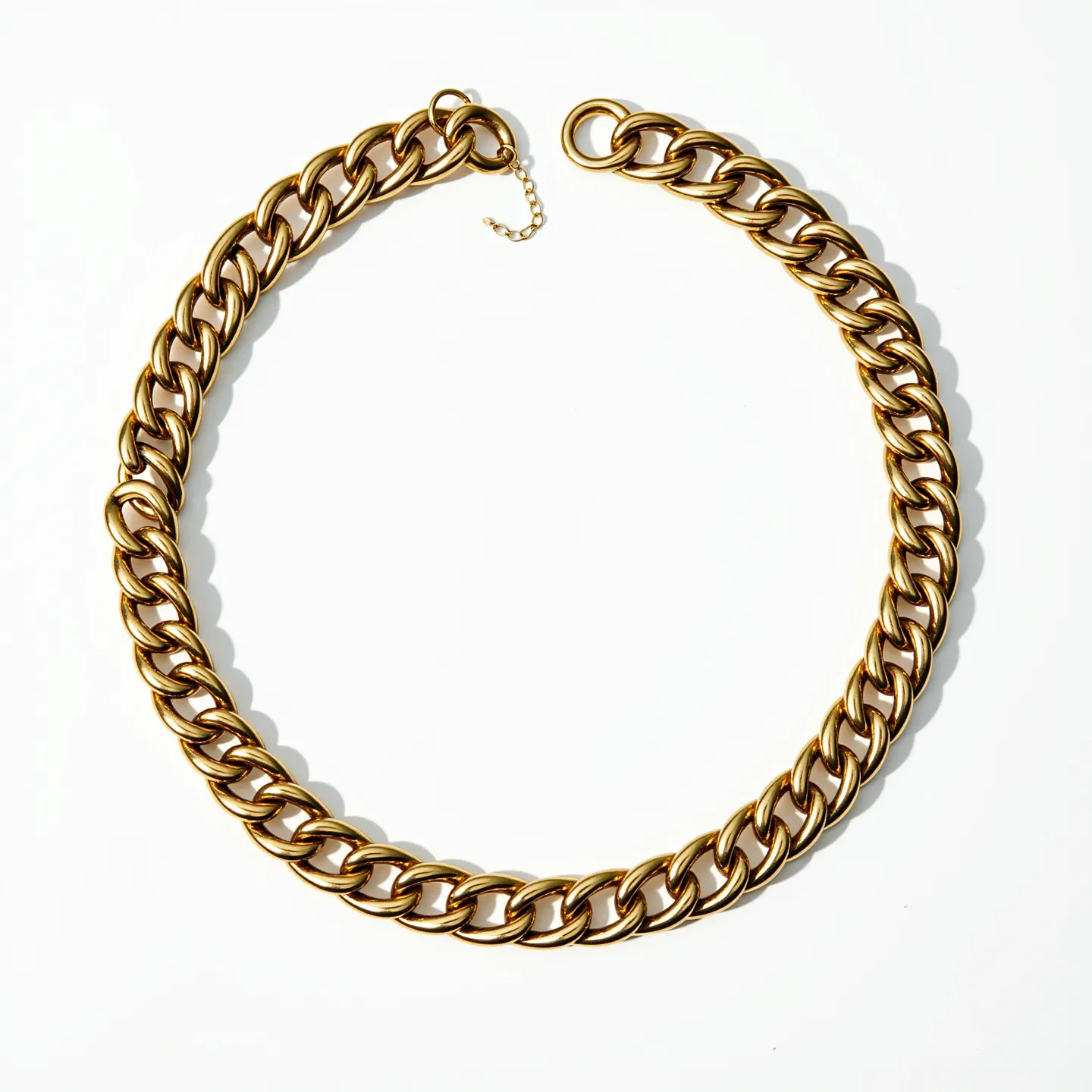 This curb chain features a series of evenly sized, interlocking links with a smooth and polished finish, suggesting it is made of a metal, likely gold or gold-toned material. It includes a simple ring clasp that allows for secure fastening. There are no visible gems or stones embedded in the links, maintaining a clean and uniform appearance throughout the piece. The chain also includes a short extension of smaller links near the clasp, adding a touch of adjustability to the design.