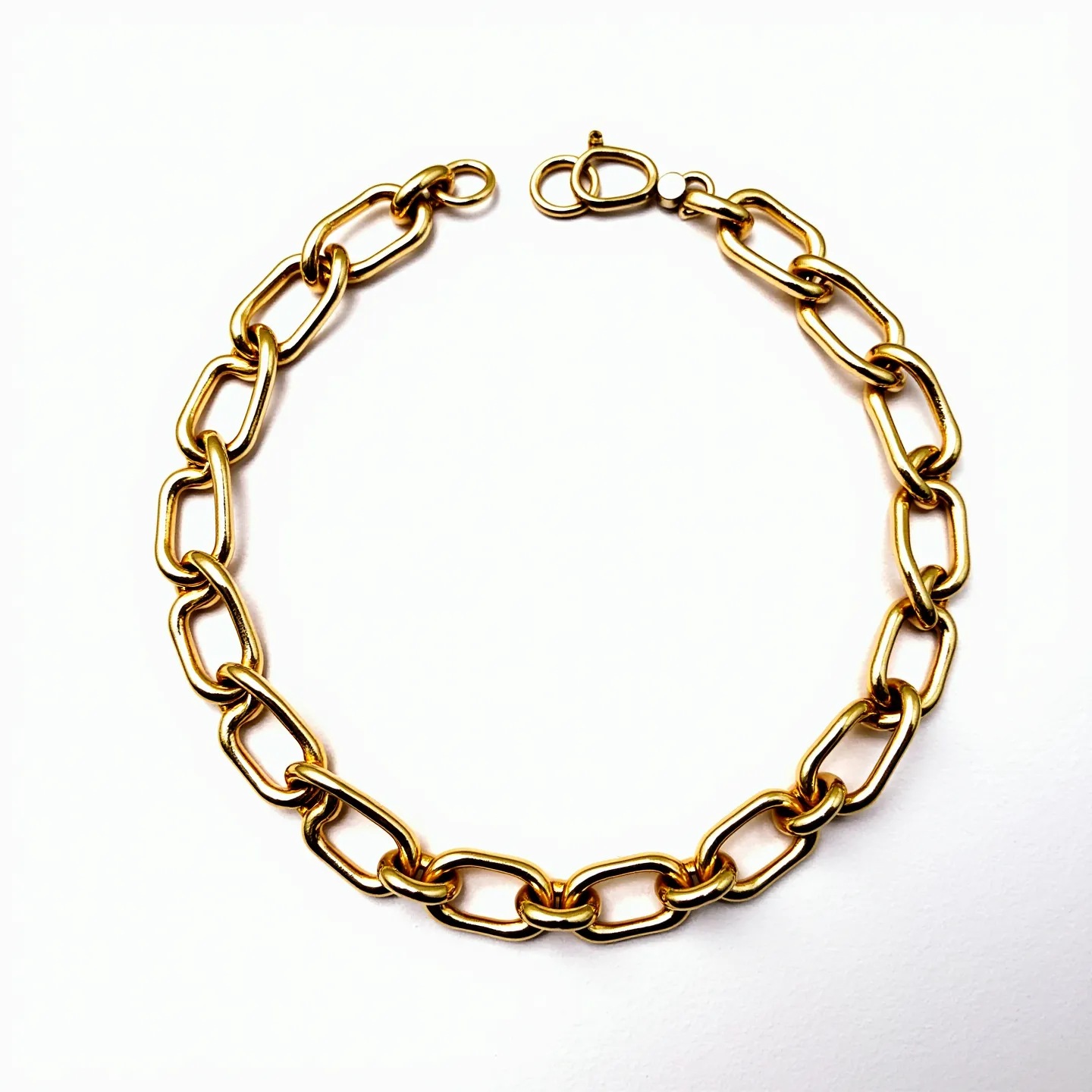 This curb chain is composed of a series of interlocking oval links with a smooth, polished finish, giving it a sleek appearance. The material appears to be gold-toned metal, which may suggest a composition of gold or gold-plated material, although the exact material is not specified. The design does not include any gems or stones, focusing instead on the shine and elegance of the metal itself. The chain features a lobster clasp, providing a secure and functional method of attachment.