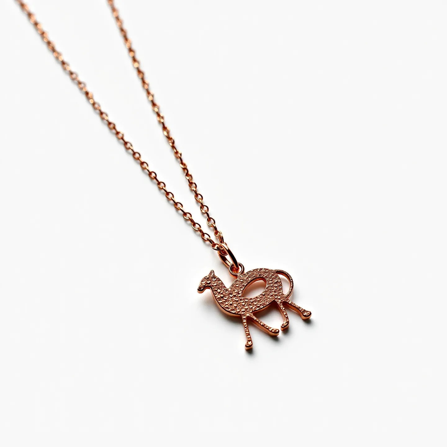 This custom charm necklace features a delicate chain crafted from rose gold, providing a warm and luxurious appearance. The central charm is shaped like a camel, with intricate texturing that adds visual interest and detail. Attached with a simple loop bail, the charm gracefully hangs from the chain. The necklace includes a classic spring ring clasp for secure attachment, ensuring ease of wear while maintaining elegance.