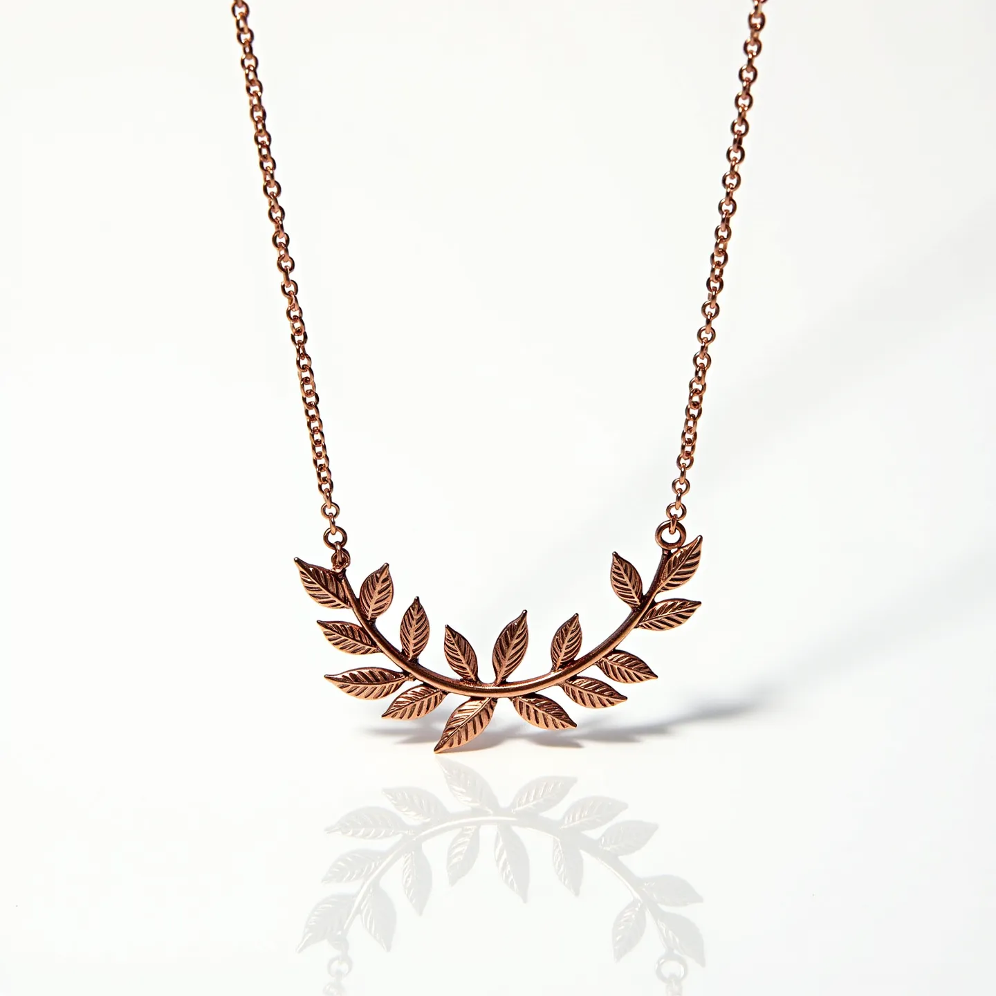 This custom necklace features a beautifully crafted centerpiece in the shape of a laurel wreath with intricately designed leaves. The necklace appears to be made of a metal with a warm, coppery finish, lending it a classic and elegant look. The chain is composed of matching links that complement the ornate design of the laurel motif. The piece is fitted with a simple and standard clasp mechanism, ensuring it is both secure and easy to wear. The overall design highlights a tasteful and timeless aesthetic, ideal for various occasions.