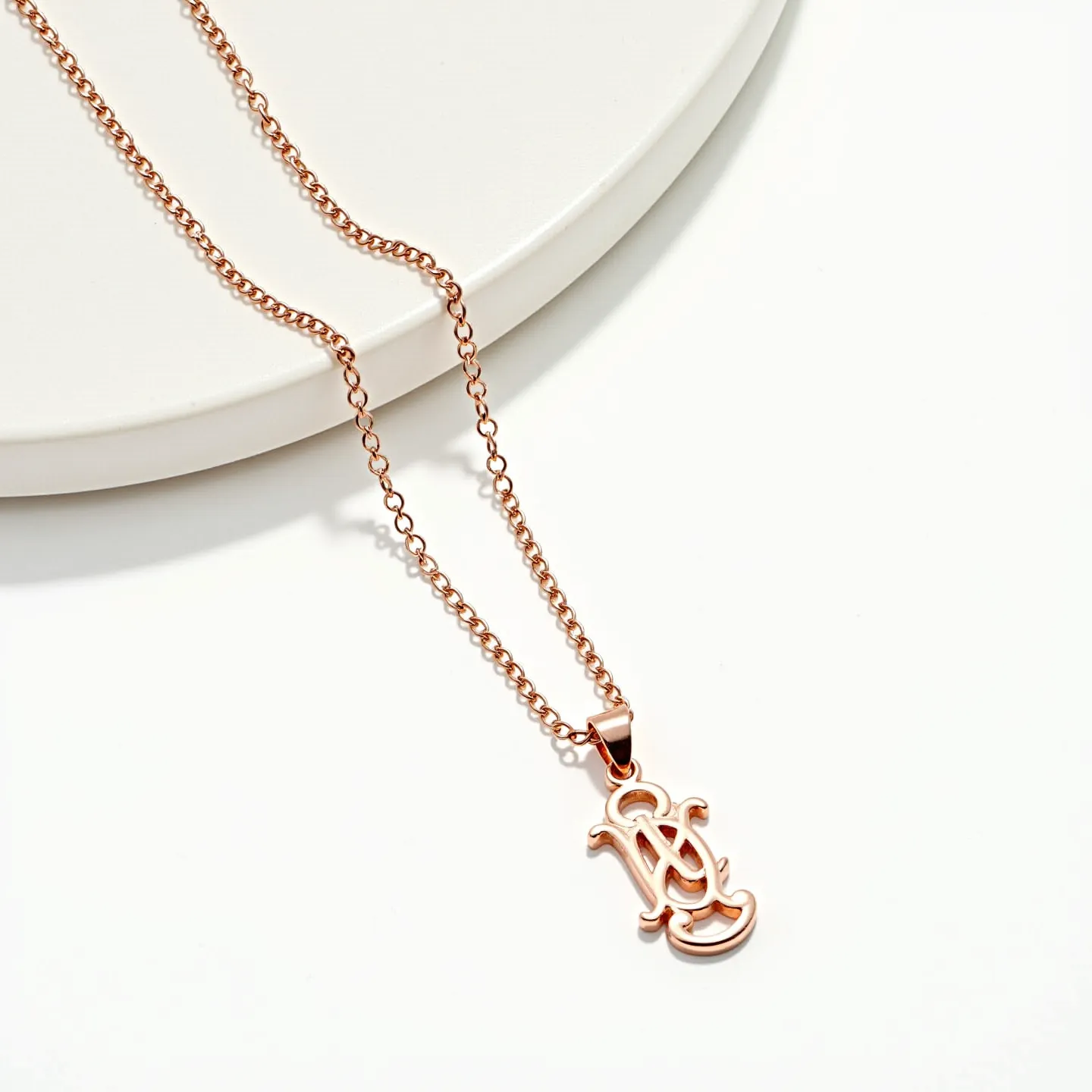 This custom necklace features a delicate rose gold chain, likely crafted from a plated or solid gold material, adding a warm and elegant tone. The pendant showcases an intricate, cursive initial design, giving it a personalized touch. The pendant is connected to the chain with a matching rose gold bail, blending seamlessly into the piece. The chain is composed of interlinked oval links, suggesting a cable chain structure, which is both simple and durable. The absence of visible gemstones gives the necklace a refined and minimalist appeal.