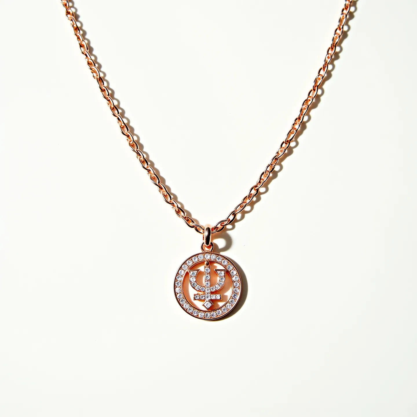 This custom necklace features a delicate rose gold chain linked by oval-shaped loops, creating an elegant and timeless look. The centerpiece is a round pendant set in rose gold, showcasing a circular array of small, sparkling white stones, likely diamonds or cubic zirconia, in a pavé setting. The pendant's inner design consists of a symmetrical symbol encrusted with the same stones, enhancing its intricate appearance. The clasp appears to be a standard lobster claw, offering secure and easy attachment for the wearer.