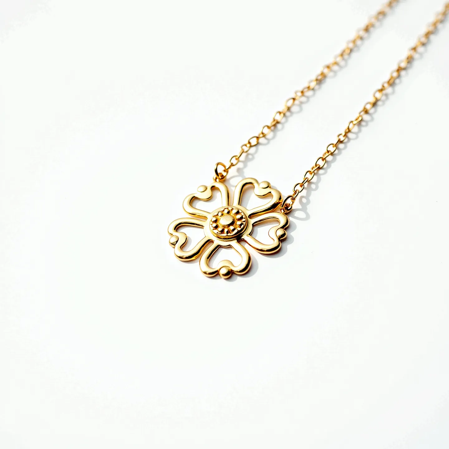 This daisy necklace features a delicate design crafted from polished gold-toned metal. The daisy pendant is intricately shaped with petal-like outlines forming a symmetrical floral pattern. At the center of the pendant, a raised circular element adds texture and dimension, resembling a stylized daisy core. The pendant is securely attached to a fine chain, which is composed of small, closely linked loops that enhance the necklace's elegant appearance. The necklace is likely fastened with a small clasp, providing a secure yet subtle closure.