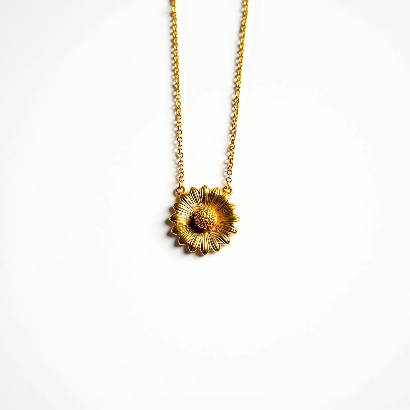 This daisy necklace features a charming daisy-shaped pendant intricately crafted from metal with a warm golden hue, giving it an elegant and timeless appeal. The petals are delicately sculpted, radiating from a textured center that adds dimension and interest to the design. The pendant is seamlessly integrated into a fine chain, also in a matching golden tone, enhancing the cohesive aesthetic of the piece. The necklace likely secures with a standard clasp, providing both functionality and ease of wear.