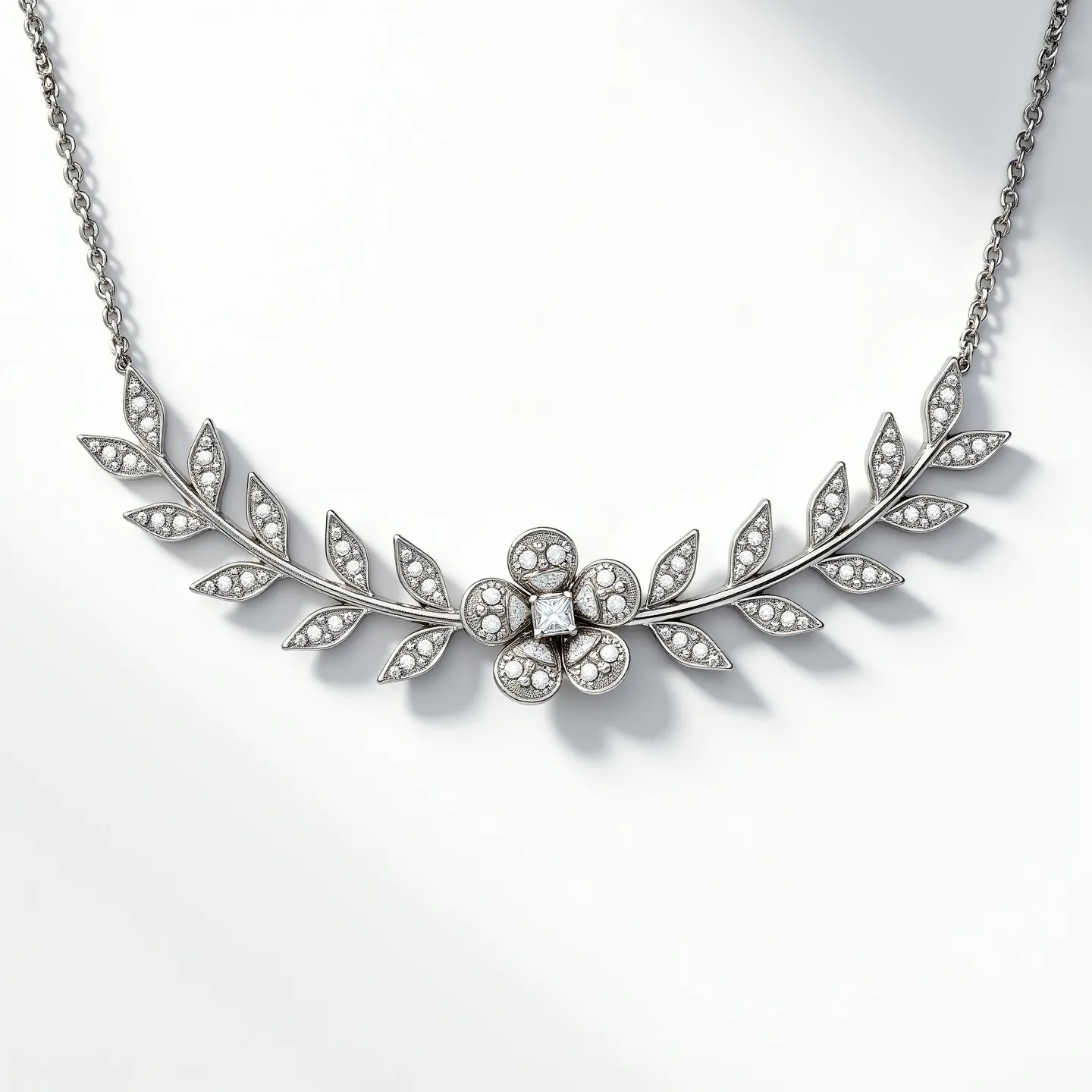 This diamond choker necklace features an intricately designed band resembling a floral motif with leaves. Each leaf is adorned with small, round-cut diamonds set in pave settings. At the center sits a flower design with a prominent square-cut diamond surrounded by smaller diamonds on the petals. The necklace appears to be made from a white metal, likely platinum or white gold, enhancing the brilliance of the diamonds. The chain and clasp are composed of the same metal, providing a seamless and elegant look.