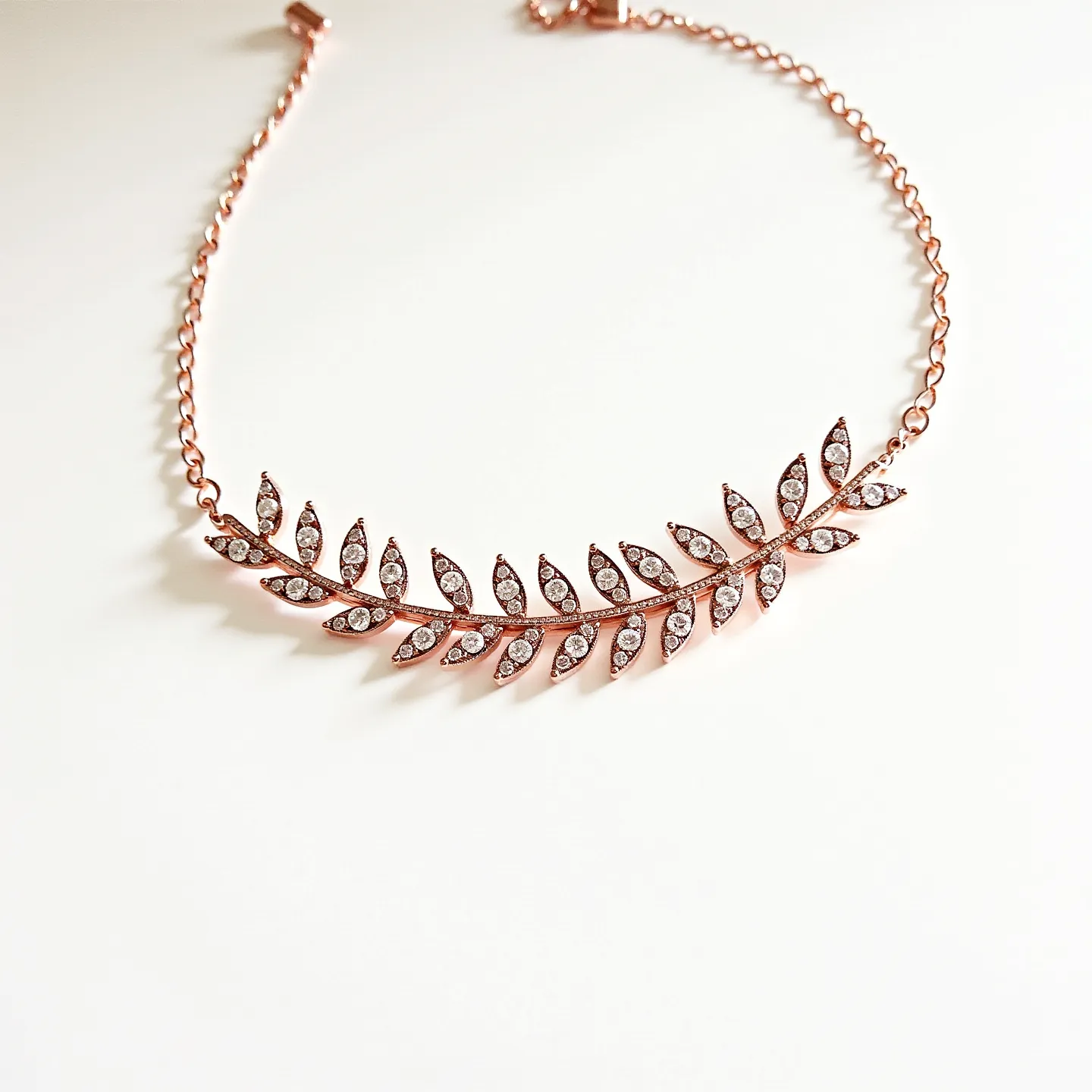 This diamond choker necklace features a delicate leaf design, crafted from rose gold. Adorned with numerous small round-cut diamonds, each leaf is intricately inlaid with these sparkling gems, enhancing the elegance of the necklace. The necklace is constructed with a simple rose gold chain that allows for a comfortable fit around the neck. It is equipped with a secure clasp mechanism that seamlessly blends with the overall design, ensuring both functionality and style.