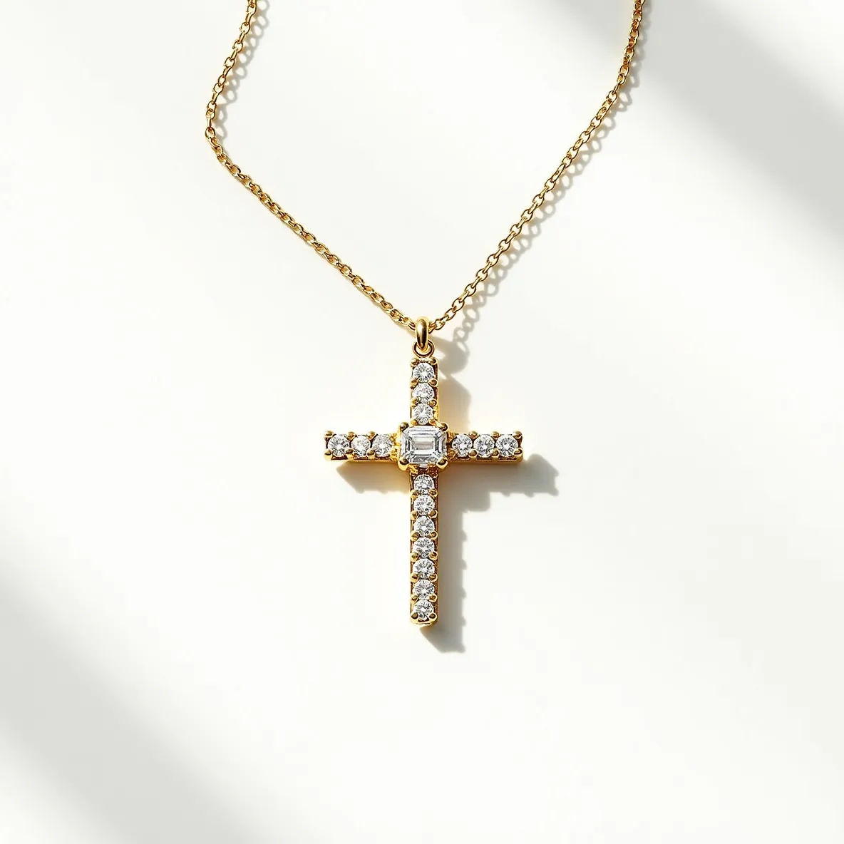 This diamond cross necklace features a cross pendant adorned with numerous round brilliant cut diamonds set in prongs along its vertical and horizontal arms. At the center of the cross, a larger, emerald-cut diamond is prominently displayed, adding a unique focal point. The diamonds are set into a warm, gold metal setting that enhances their brilliance and sparkle. The necklace is attached to a delicate gold chain with circular links, providing an elegant drape. The chain is equipped with a standard lobster clasp, ensuring a secure closure while allowing for easy fastening and removal.