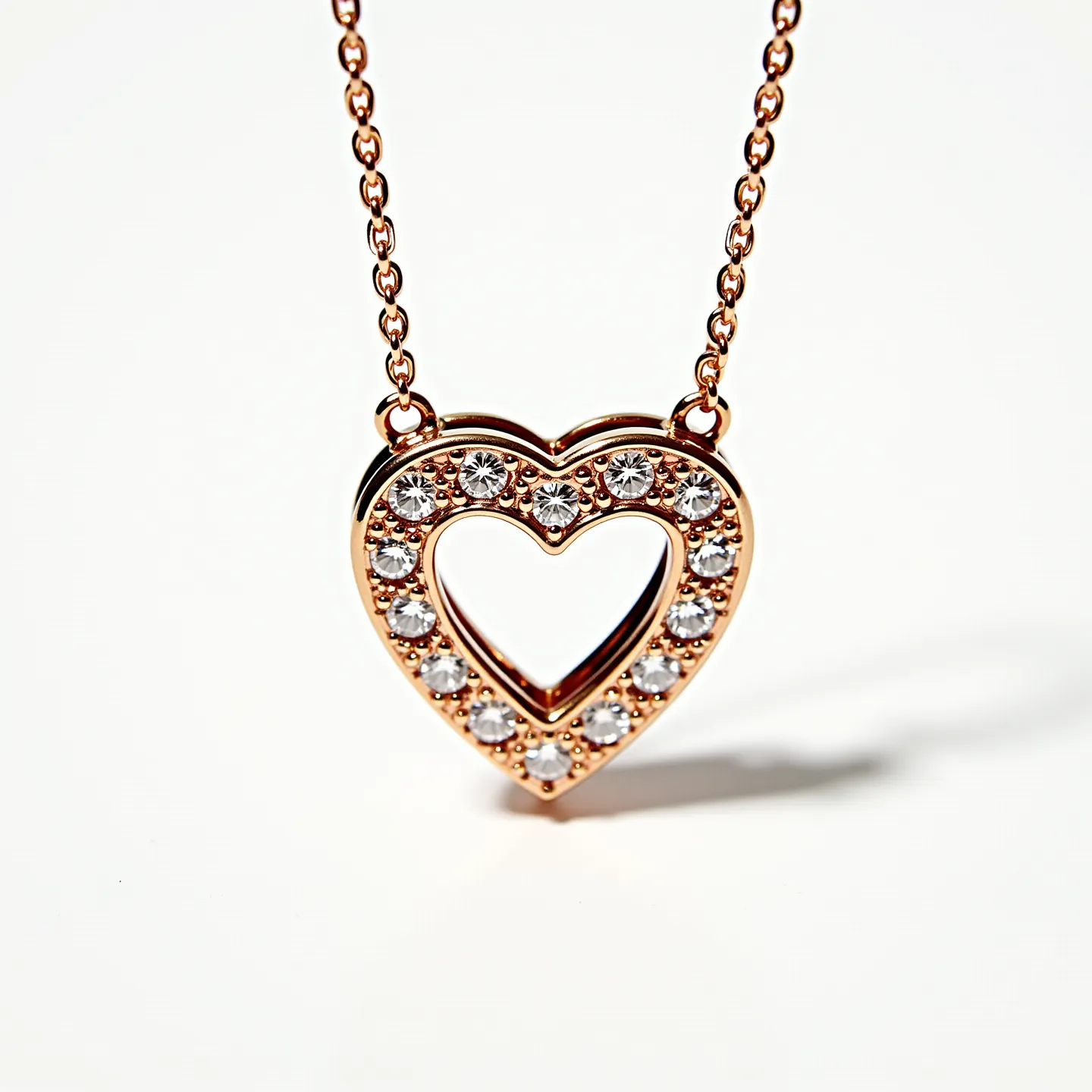 This diamond heart necklace features a delicate heart-shaped pendant adorned with round-cut diamonds, set in a polished rose gold metal. The diamonds are evenly spaced around the edges of the heart, enhancing its elegant design. The pendant is connected to a matching rose gold chain, which complements the warm hues of the setting. The necklace is completed with a secure clasp, ensuring it stays in place while worn, making it both a stylish and practical piece of jewelry.