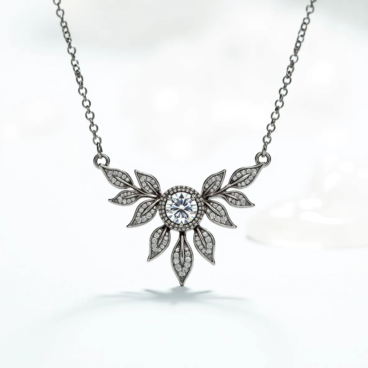 This diamond necklace features a central round-cut diamond set in a bezel setting, surrounded by a decorative arrangement resembling a floral or leaf motif. The intricate design incorporates numerous smaller diamonds, set in a pavé style, accentuating each petal-like element surrounding the main stone. The necklace appears to be crafted from a silver-toned metal, which complements the brilliance of the diamonds and enhances the overall elegance. The chain is delicate, and likely consists of fine metallic links, leading to a clasp that ensures secure attachment when worn.