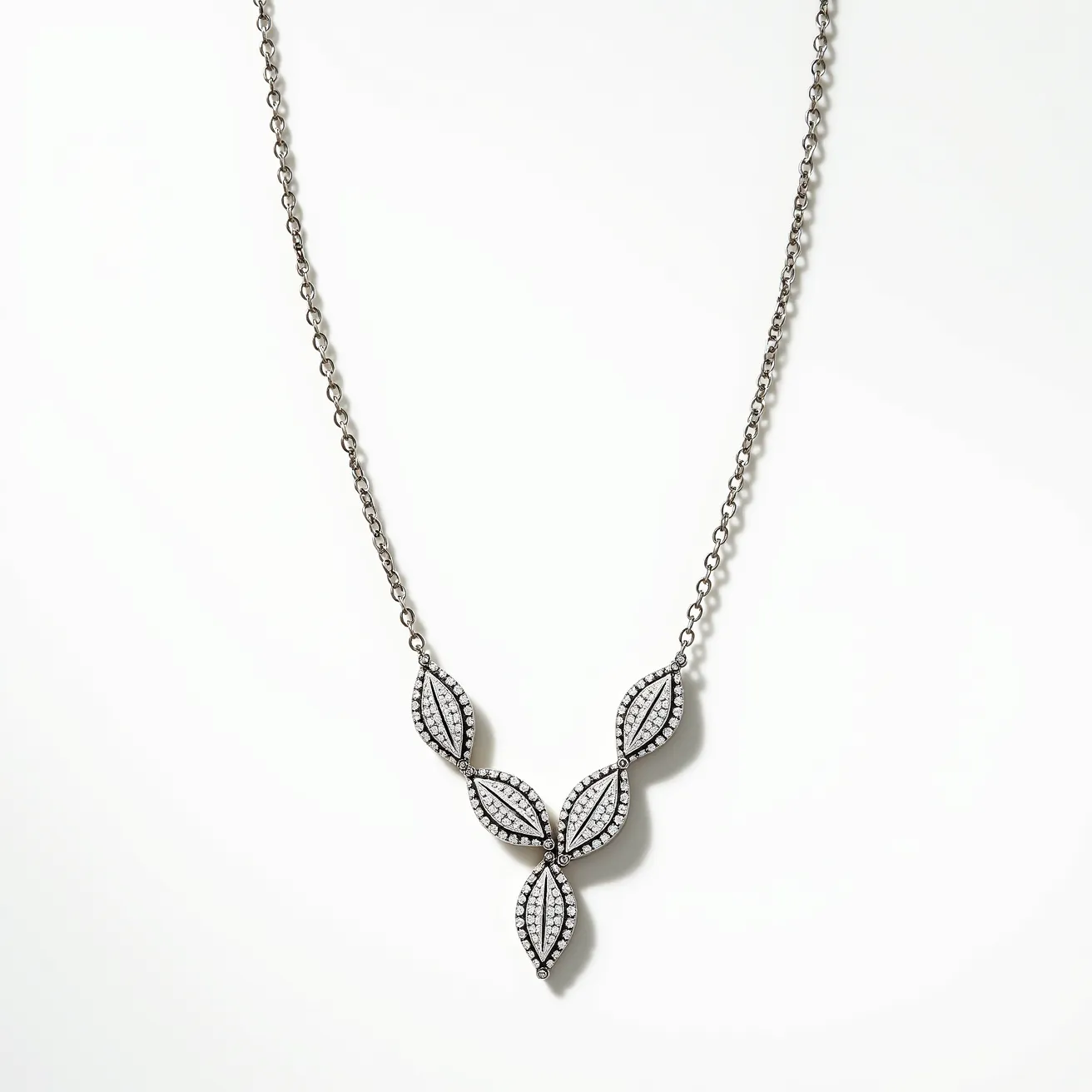 This diamond necklace showcases a series of four marquise-shaped pendants set with numerous small, brilliant-cut diamonds. Each pendant features a design reminiscent of leaves, where the diamonds are arranged in a pavé setting, creating a continuous sparkle across the surface. The pendants are centrally connected, forming a v-shaped motif. The necklace is crafted from a metal that appears to be white gold or platinum, complementing the brilliance of the diamonds. It is finished with a delicate chain and a simple clasp attachment for secure wear.