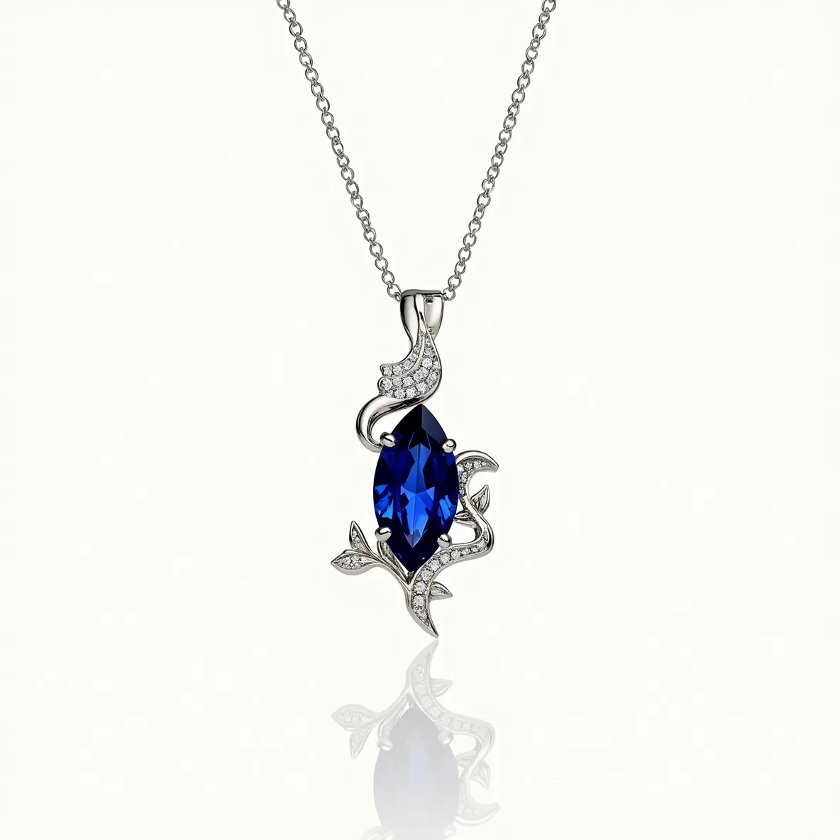 This diamond necklace features a striking design with a central marquise-cut blue gemstone, which is artfully surrounded by intricate silver or white gold metalwork. The metalwork includes delicate, flowing lines that are encrusted with small round-cut diamonds, adding a touch of sparkle and elegance to the piece. The pendant is gracefully attached to a fine chain, likely made of the same metal as the pendant itself. The attention to detail in the setting highlights the brilliance of both the blue gemstone and the diamonds, creating a captivating and luxurious look.