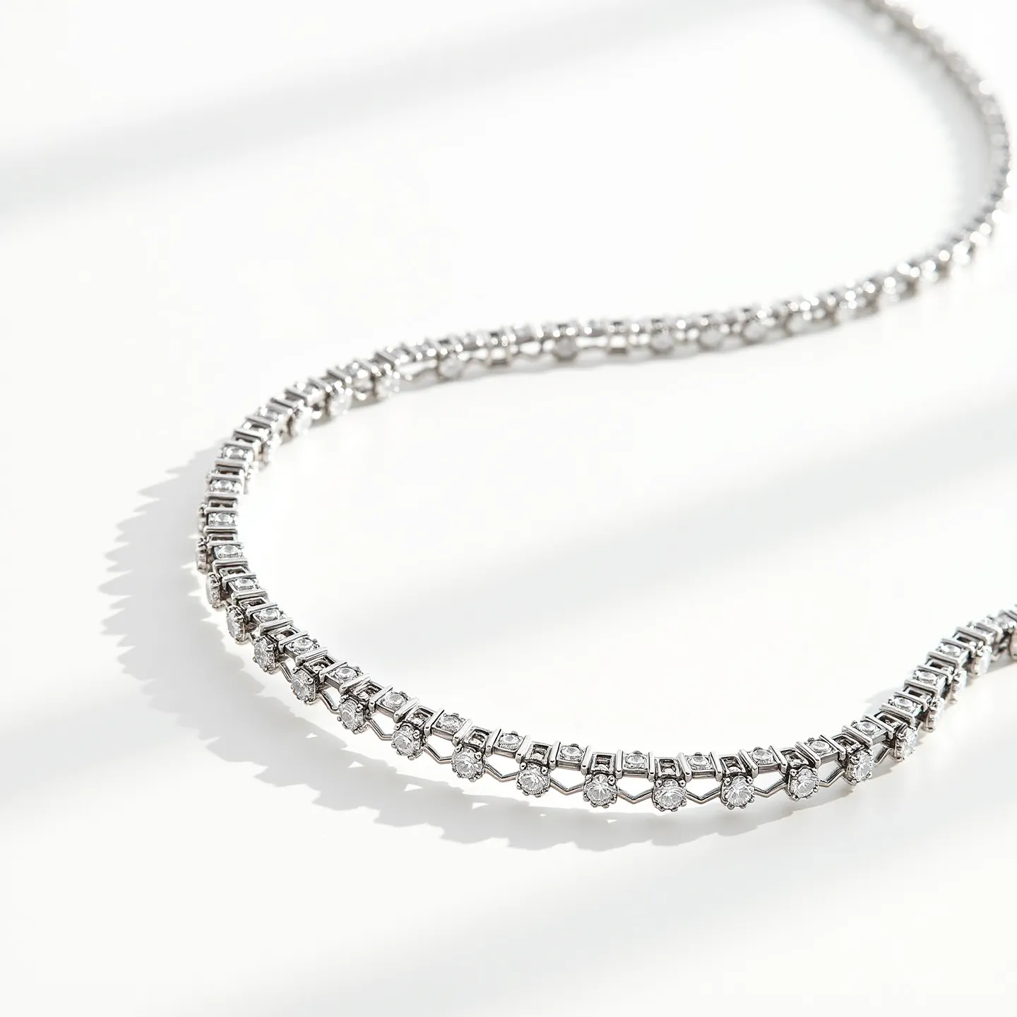 This diamond tennis necklace features a series of closely set, round-cut diamonds, each meticulously aligned to create a continuous, elegant shimmer across the piece. The diamonds are secured in a prong setting, which allows them to catch light from multiple angles, enhancing their brilliance. The base metal of the necklace appears to be crafted from white gold or platinum, offering a sleek and modern finish that complements the stones beautifully. The necklace is completed with a box clasp, providing both security and a seamless appearance when worn.