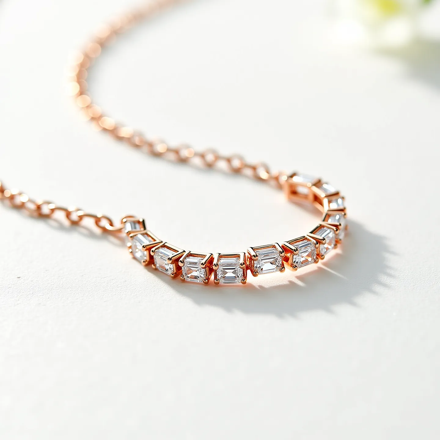 This diamond tennis necklace features a series of baguette-cut diamonds set in a classic prong setting, allowing each gem to capture and reflect light with exceptional brilliance. The necklace is crafted with a rose gold chain, enhancing the elegance of the stones and providing a warm contrast to their sparkle. The stones are uniformly aligned, giving the piece a harmonious and continuous appearance. The clasp is subtly integrated into the design, ensuring both security and aesthetics are upheld. Overall, the necklace embodies sophistication through its meticulous craftsmanship and choice of materials.