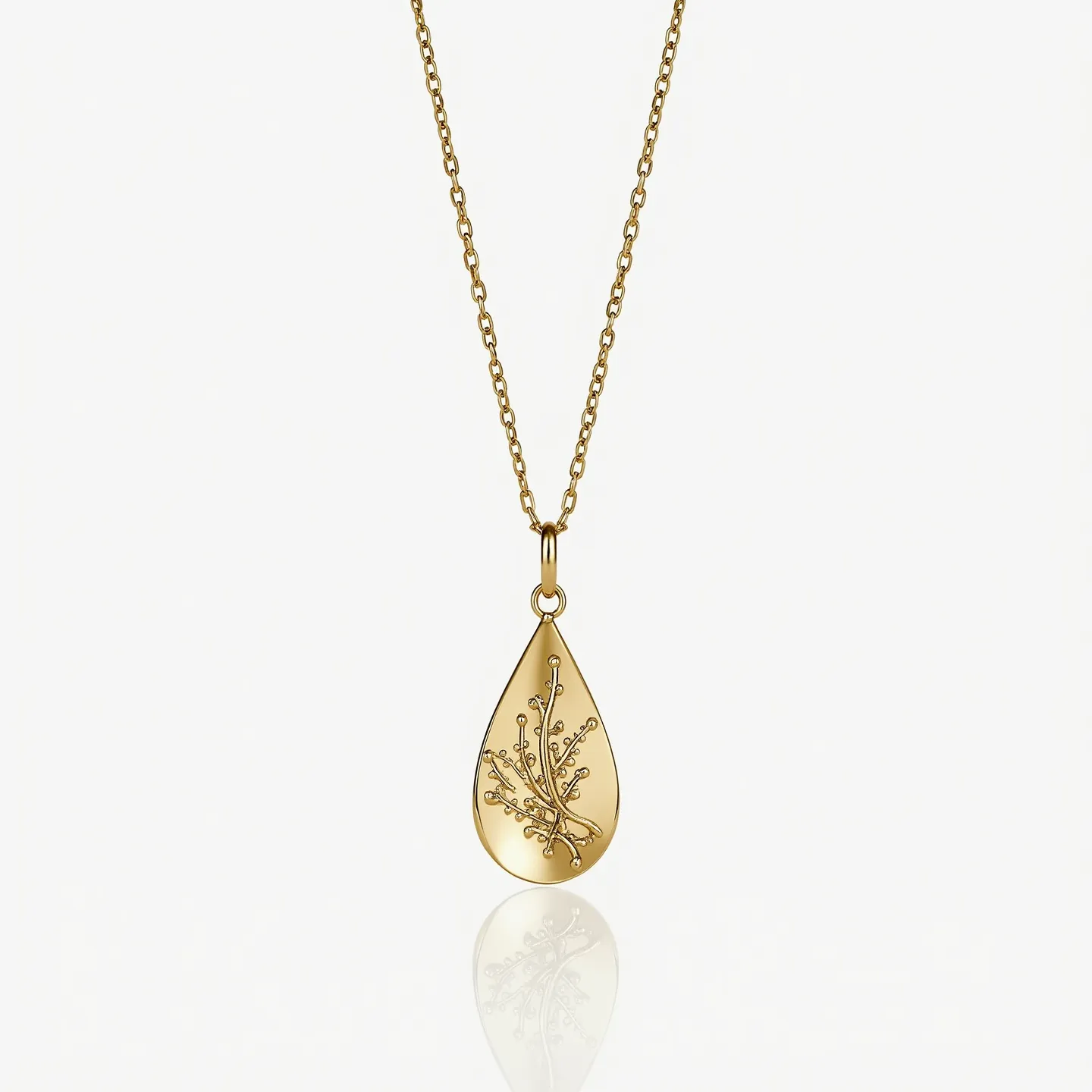 This drop necklace features a teardrop-shaped pendant crafted from a polished gold material, creating an elegant and sophisticated appearance. The pendant is adorned with an intricate engraved design resembling a delicate branch, adding a touch of natural elegance. Suspended from a fine gold chain, the necklace exhibits a harmonious balance between the dainty chain and the prominent pendant. The chain is made up of small, interlocking links that contribute to its fluid movement. The pendant is attached to the chain with a simple gold loop, ensuring a secure and stylish connection, while the necklace is likely fastened with a traditional clasp to ensure ease of wear.