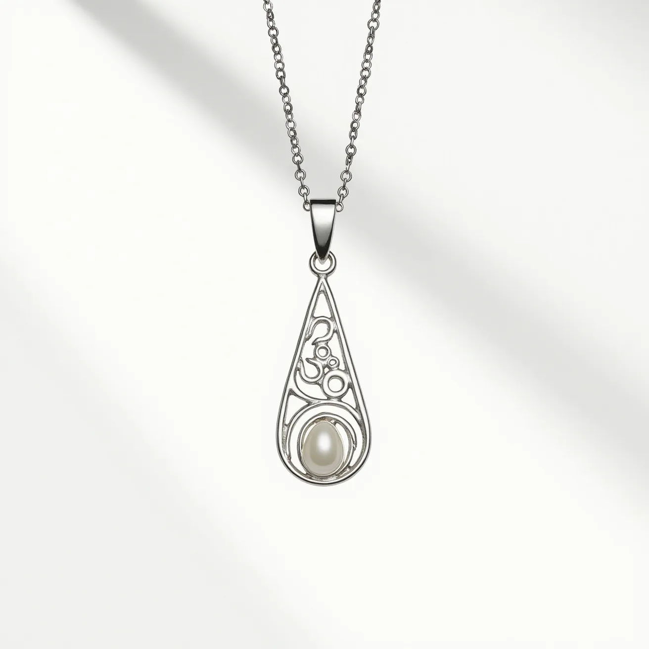 This drop necklace features a sleek silver chain and a teardrop-shaped pendant, expertly crafted from silver-toned metal. Within the openwork design of the pendant, an artistic arrangement of numerals and circles adds an intricate touch. At the center of the teardrop, a lustrous pearl-like stone is set in a bezel setting, which enhances its elegance. The pendant is gracefully attached to the chain with a classic bail, allowing it to dangle freely. The combination of the metallic sheen and the smooth pearl-like gem creates a harmonious and sophisticated piece of jewelry.