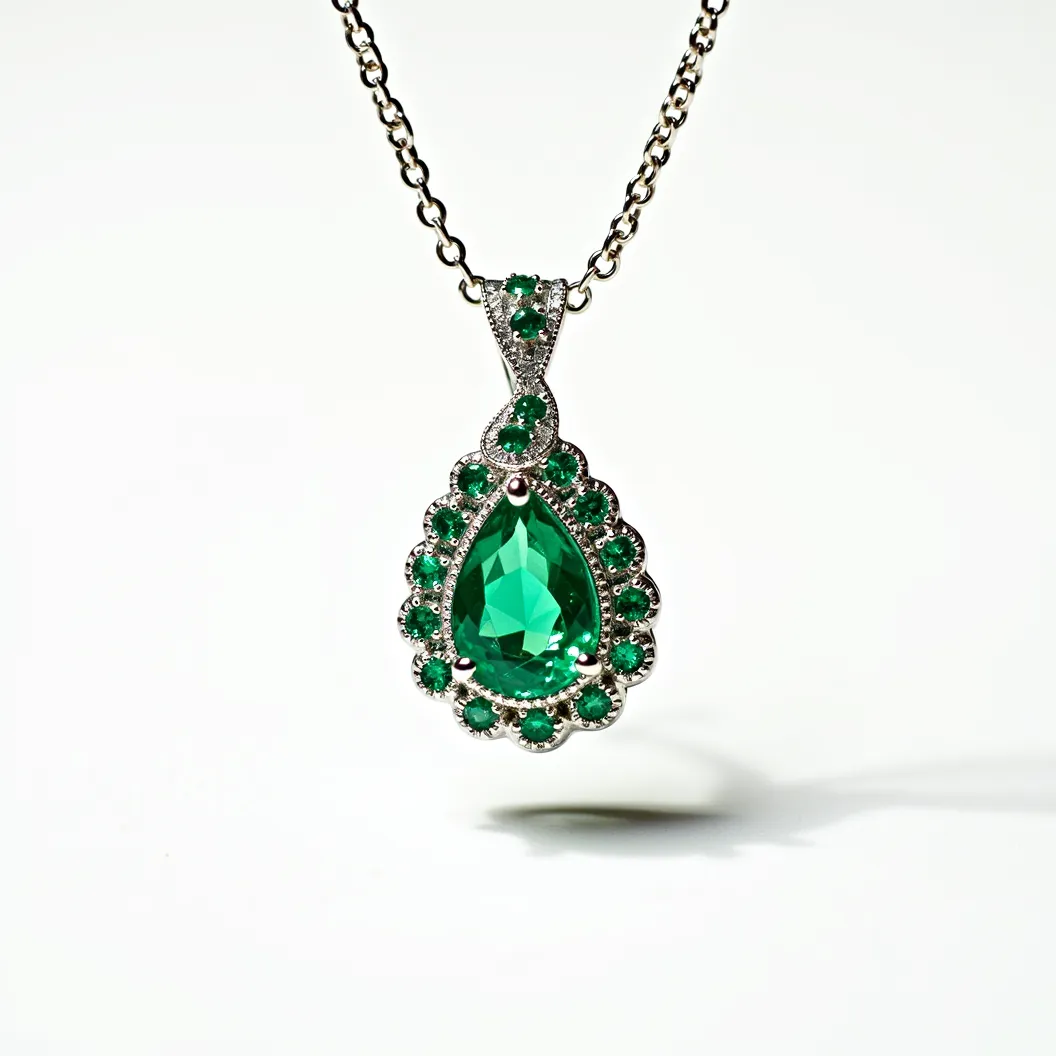 This emerald necklace features a stunning pear-shaped emerald as its centerpiece, exquisitely set in a prong setting to enhance its vibrant green hue. The emerald is surrounded by an array of smaller round-cut emeralds, adding depth and brilliance to the overall design. These gems are meticulously set in a complementary metal, likely white gold or platinum, which highlights their vivid color. The pendant attaches to a delicate chain with a secure clasp, designed to ensure both elegance and safety. The detailed craftsmanship in the setting and arrangement of the stones showcases both sophistication and artistry.