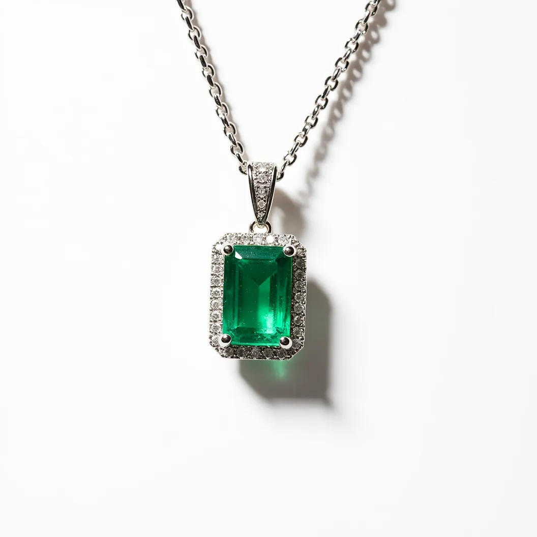 This emerald necklace features a prominent rectangular-cut emerald as its centerpiece, set in an elegant manner with a halo of small, round-cut diamonds encircling it, enhancing the vibrant green hue of the gemstone. The emerald is secured by a four-prong setting, allowing light to pass through and maximize its brilliance. The pendant is attached to a classic chain via a diamond-encrusted bail, which adds to the overall sparkle and sophistication of the piece. The combination of the precious stones with the fine metalwork offers a timeless and luxurious aesthetic.