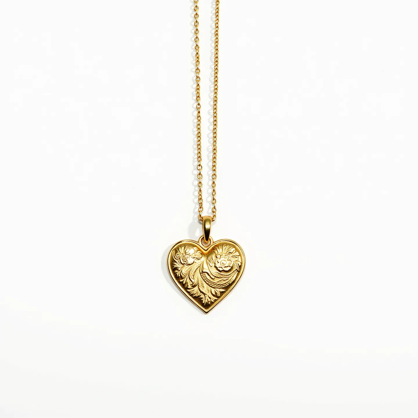 This engraved heart necklace features a beautifully crafted gold heart pendant adorned with intricate floral and swirl designs. The pendant hangs from a delicate gold chain, which is secured by a simple yet elegant clasp. The attention to detail in the engraving showcases the craftsmanship of the piece, creating a timeless and classic look. The gold material gives the necklace a warm and luxurious appearance, making it a versatile accessory suitable for various occasions.