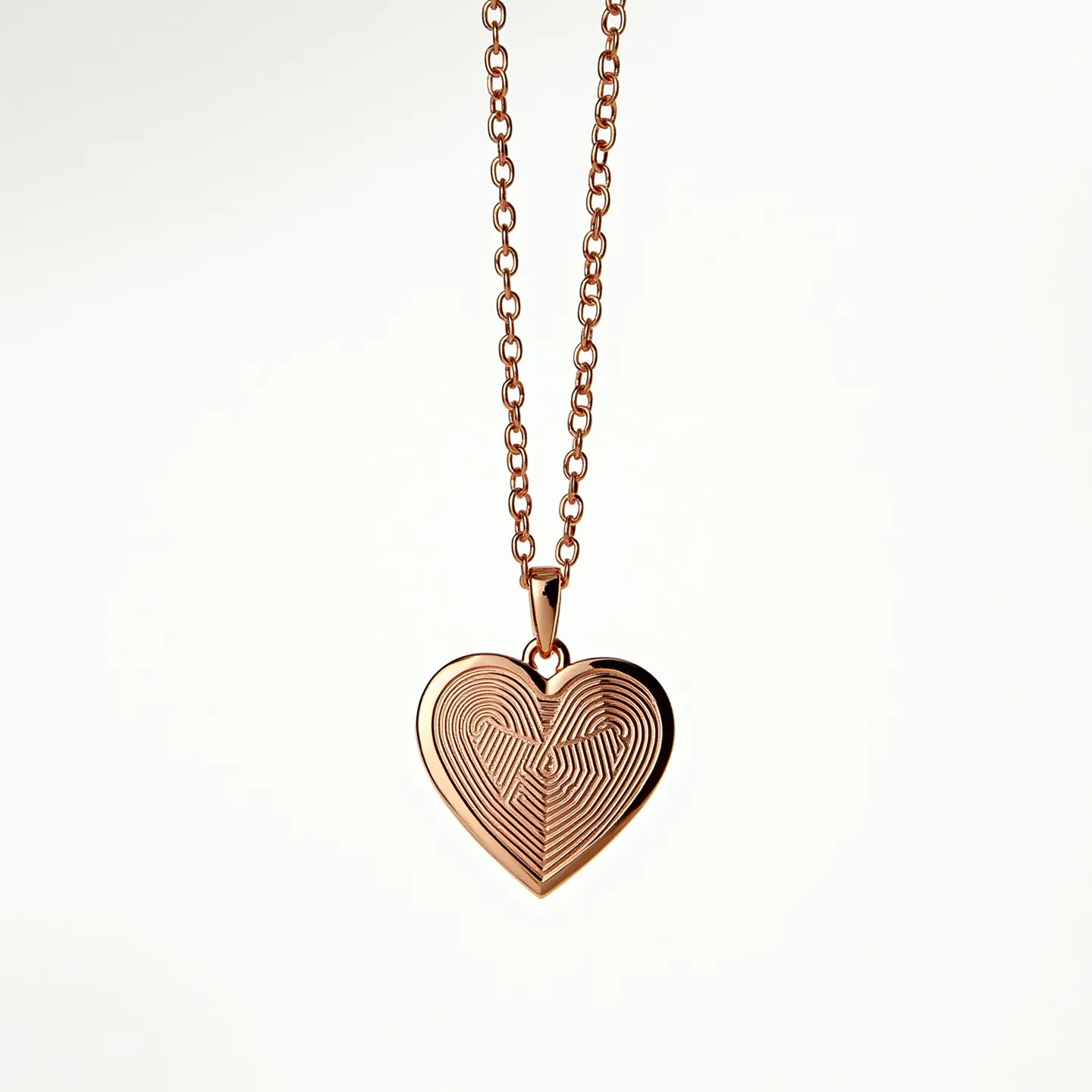 This engraved heart necklace features a rose gold finish, giving it a warm and elegant appearance. The heart-shaped pendant is intricately engraved with a symmetrical pattern, adding a touch of sophistication. The pendant is attached to a matching chain through a polished bail. The chain consists of interlocking links, providing durability and a complementary design. The clasp type is not visible, but it likely blends seamlessly with the overall aesthetic, ensuring secure wear.