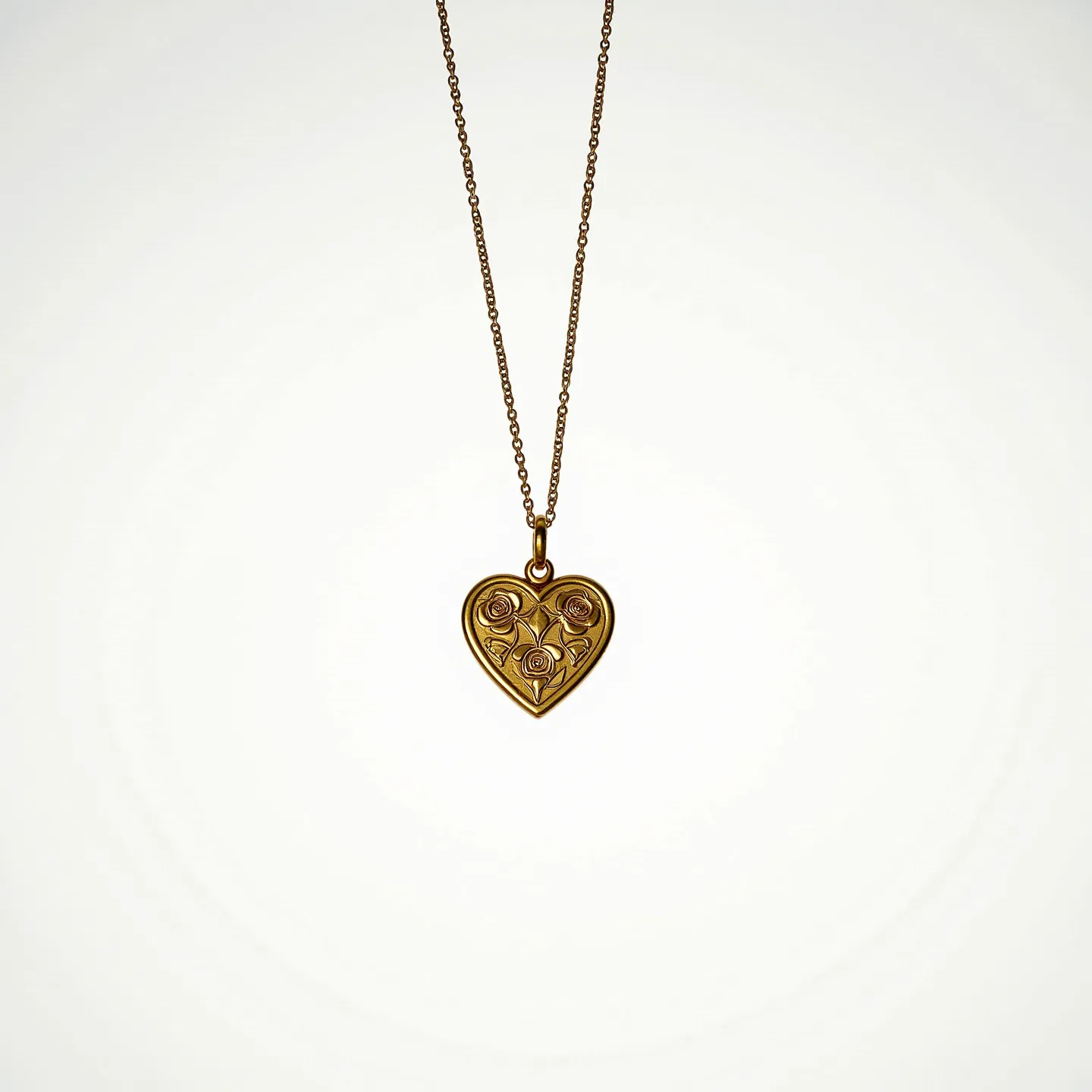 This engraved heart necklace features an ornate heart-shaped pendant crafted from a gold-toned metal, intricately designed with floral patterns. The pendant showcases three symmetrical rose motifs that add a delicate charm to its appearance. The metal surface appears polished, ensuring a smooth, reflective quality that enhances the elegance of the piece. The necklace is attached to a fine chain, also in a gold-tone, which complements the pendant seamlessly. A simple loop bail connects the pendant to the chain, providing stability and ease of movement for the piece when worn.