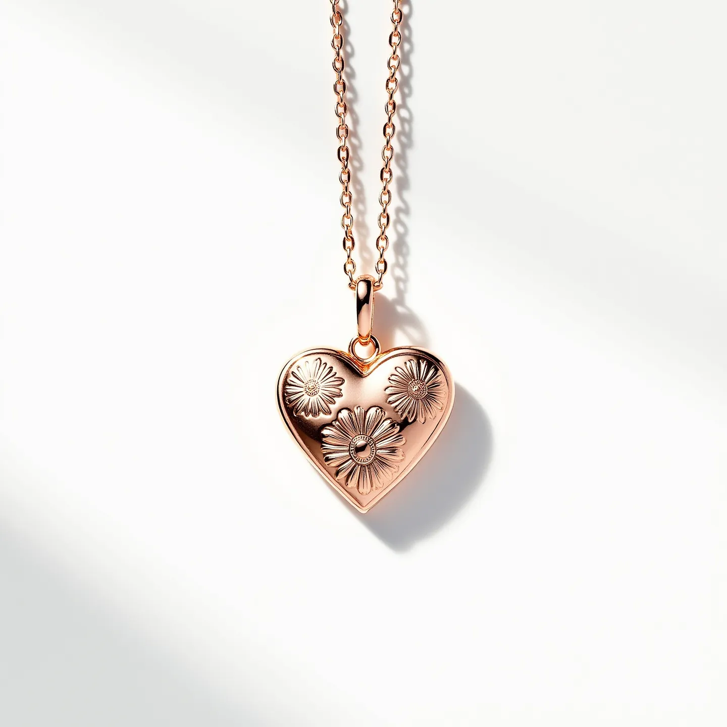 This engraved heart necklace features a polished rose gold finish, artfully adorned with intricate floral engravings on its surface. The pendant hangs elegantly from a delicate chain, which appears to be crafted from a matching rose gold material, enhancing the overall aesthetic with a warm and luxurious glow. The pendant is securely attached to the chain with a small, smooth bail that ensures fluid movement. Although the necklace does not showcase any gemstones, its charm lies in the detailed engravings that add depth and interest to the piece. The clasp is designed for simplicity and ease of use, ensuring both functionality and style in its design.