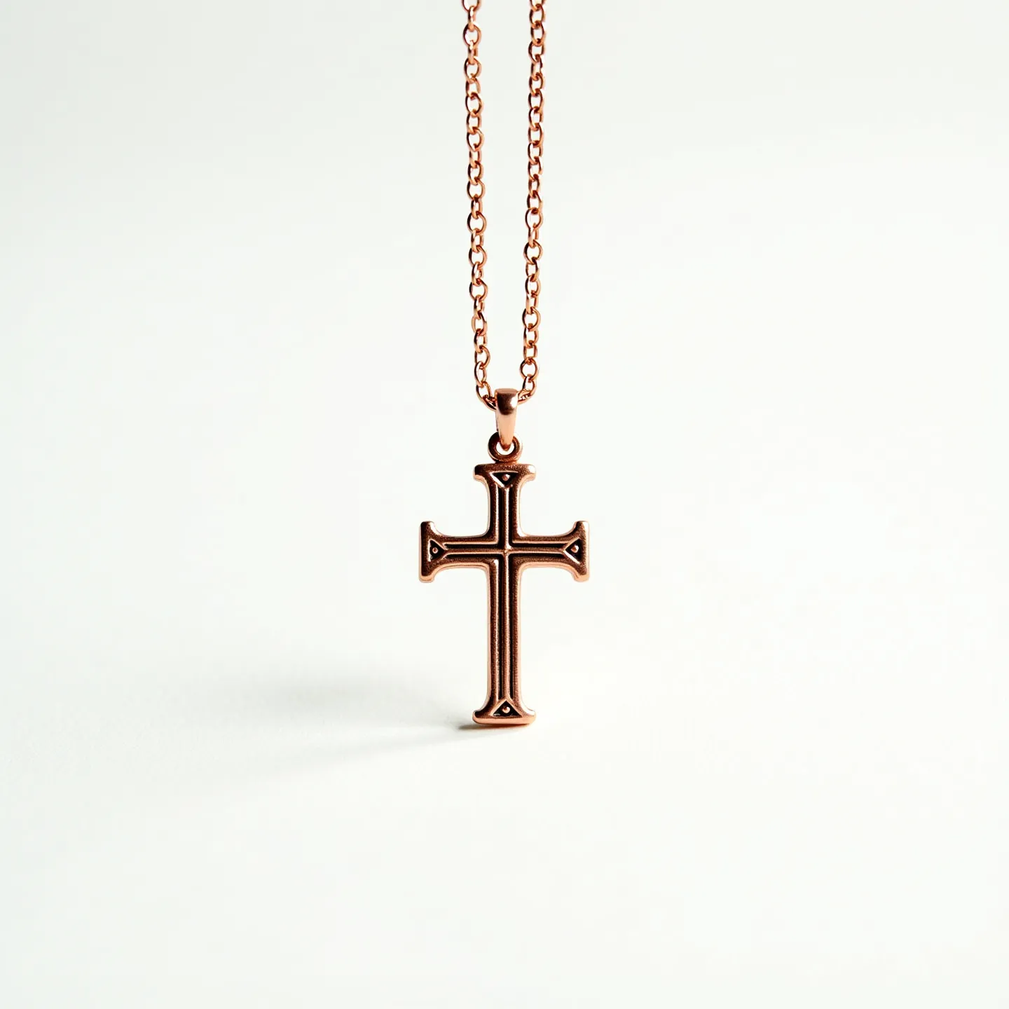 This faith necklace features a sleek and polished cross pendant crafted from what appears to be a rose gold-toned metal, exhibiting a warm and sophisticated hue. The pendant is attached to a matching chain that complements the pendant's finish. The cross’s design includes subtle engravings at its ends, adding a touch of elegance. The necklace is finished with a simple yet secure clasp, ensuring easy wearability while maintaining a stylish appearance.