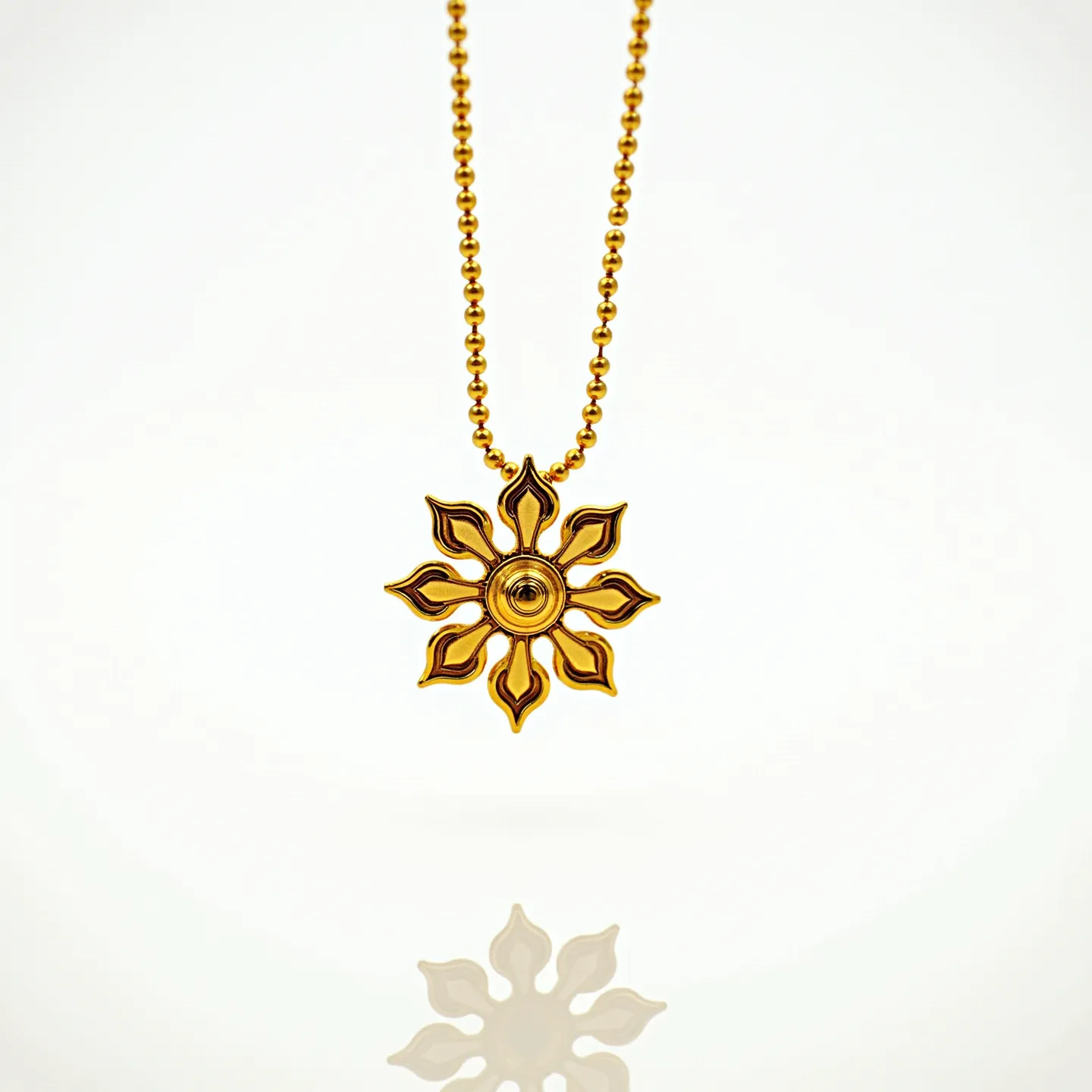 This flower necklace features a beautifully crafted pendant in the shape of a stylized flower with petal-like designs radiating outward. The pendant appears to be made from a gold-toned metal, showcasing a smooth finish that captures light elegantly. At the center of the flower, there is a spherical element, adding a sense of depth and focus to the design. The necklace is suspended from a beaded chain that matches the pendant in its metallic hue, creating a cohesive and harmonious look. The chain likely connects with a clasp, though not visible, ensuring a secure closure when worn.