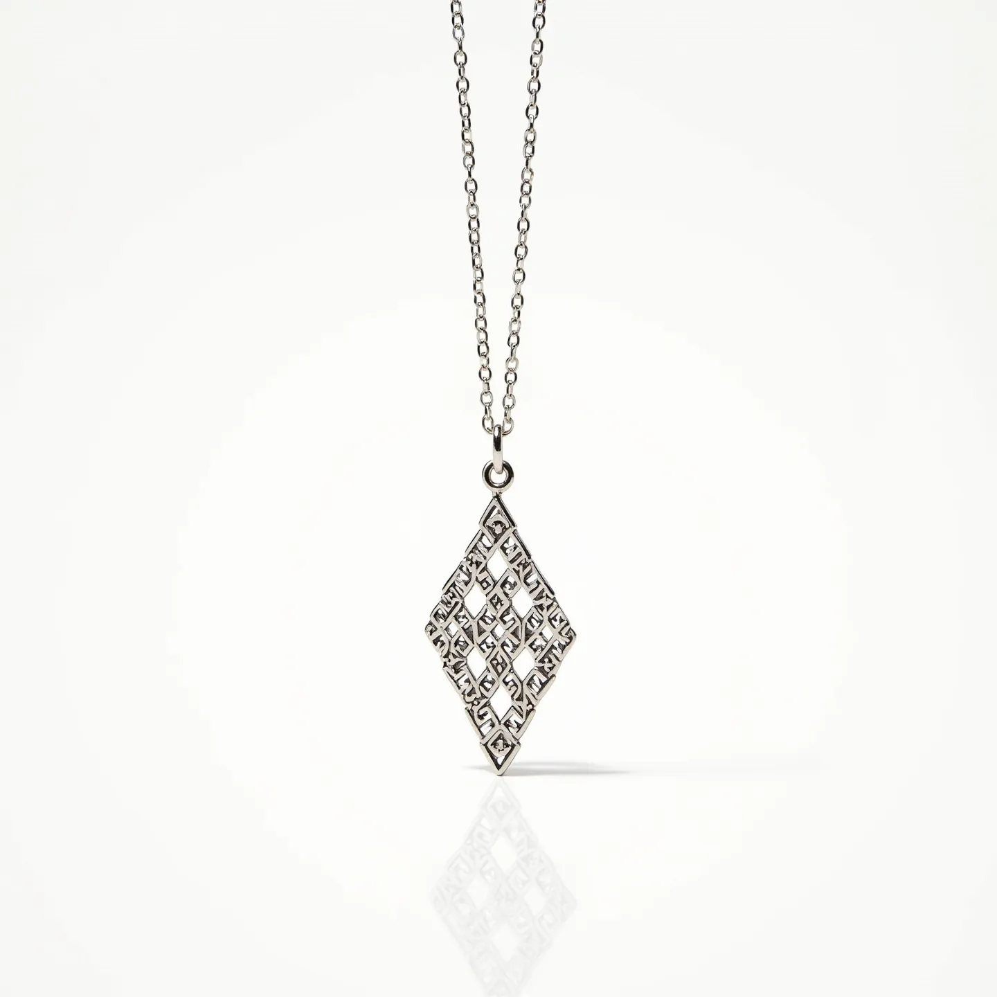 This girl's necklace showcases a delicate chain made of metal, likely silver, featuring small, evenly spaced links. At its center, a striking diamond-shaped pendant displays an intricate lattice design, crafted from the same metal as the chain. The pendant's openwork pattern creates an elegant visual contrast, but it does not appear to include any gemstones. The chain is connected to the pendant through a small jump ring, allowing the pendant to move freely. The necklace likely fastens with a small spring ring clasp, typical for necklaces of this style.