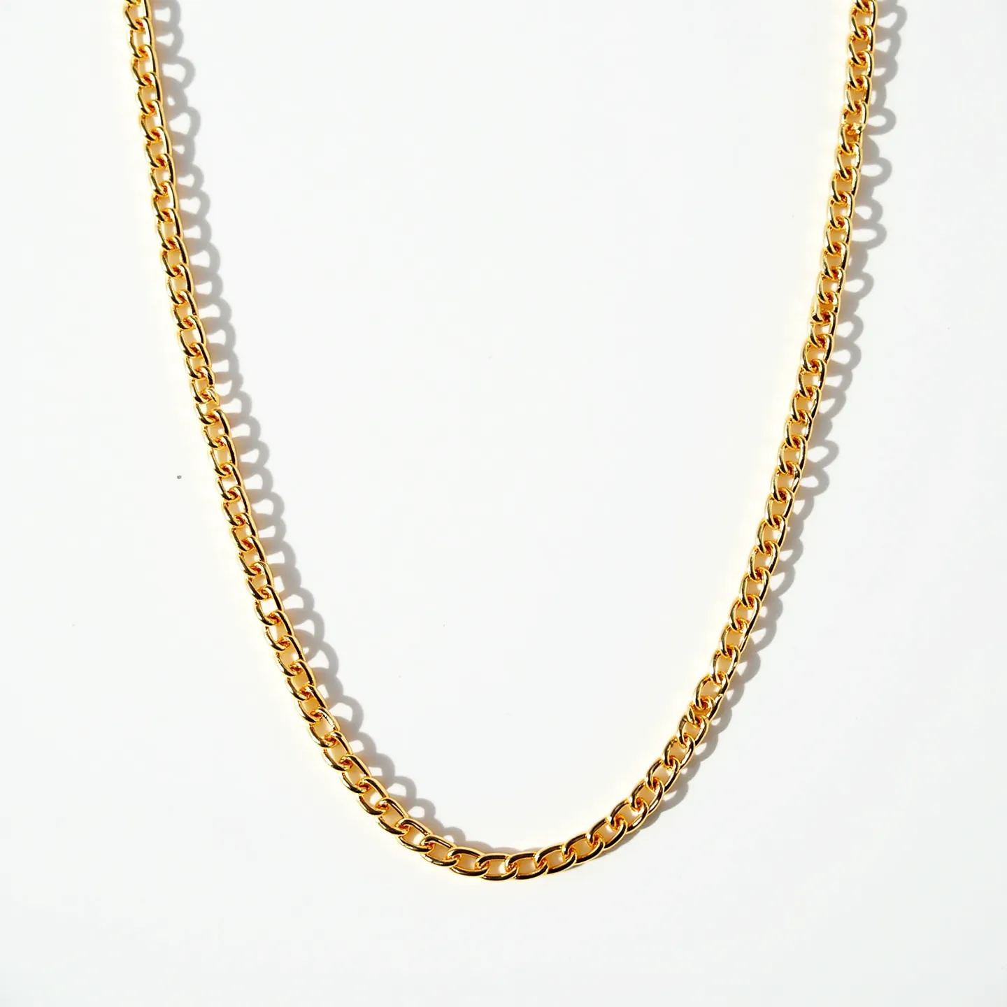 This gold chain is composed of closely linked, polished oval links that create a smooth and cohesive flow throughout its length, giving it a classic appearance. The chain showcases a uniform golden hue, indicative of its gold construction, which may suggest either solid gold or gold-plated material. There are no visible gems or stones embedded within its design. Additionally, this chain features a lobster clasp, a common choice for securely fastening the chain while allowing for easy wear. The chain's simplicity and elegance make it a versatile accessory suitable for various occasions.