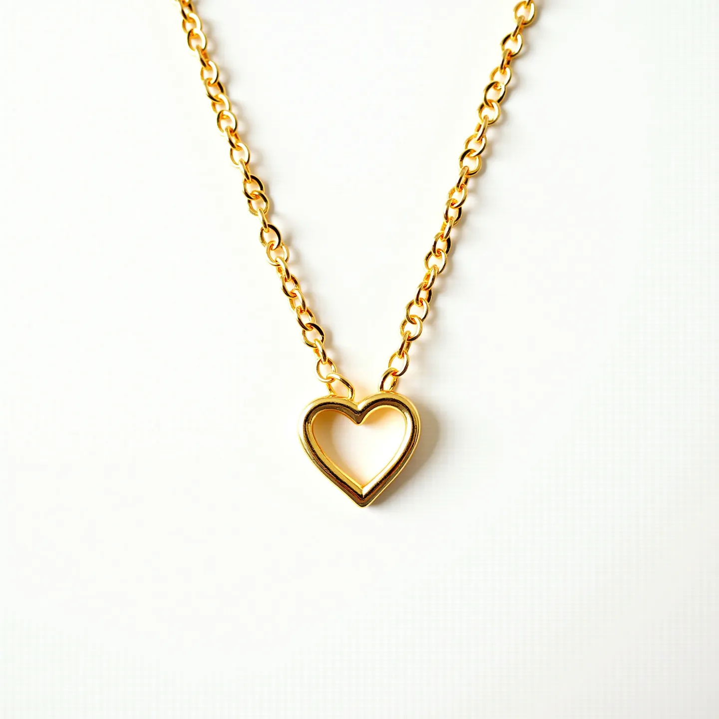 This gold chain necklace features a classic, elegant design with interlinked circular links that create a seamless and smooth aesthetic. The centerpiece of the necklace is a delicately crafted heart-shaped pendant, made entirely of gold, which adds a charming touch to the overall piece. The necklace is likely constructed from polished gold, exuding a warm and luxurious gleam. Attention to detail is evident in the evenly spaced links, reflecting both quality craftsmanship and a timeless style. The necklace is secured with a standard clasp that ensures both functionality and ease of wearing.