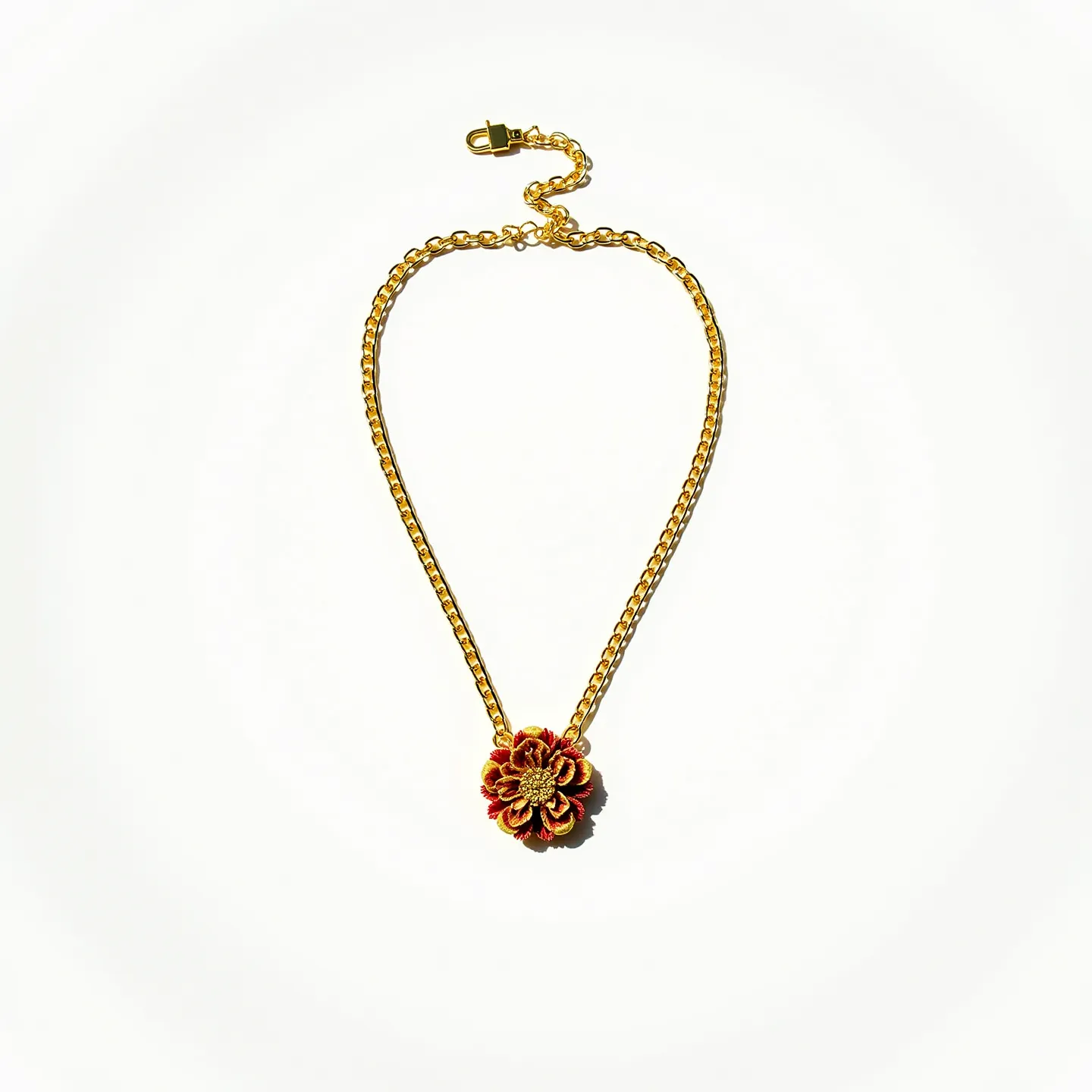 This gold chain necklace features a medium-thick chain with a prominent flower-shaped pendant at its center. The pendant is intricately designed, showcasing a combination of red and gold hues that emphasize its floral motif. The necklace is equipped with an adjustable clasp, ensuring a secure and customizable fit. The flower's detailed design and rich colors complement the gold chain, creating a striking and refined piece.