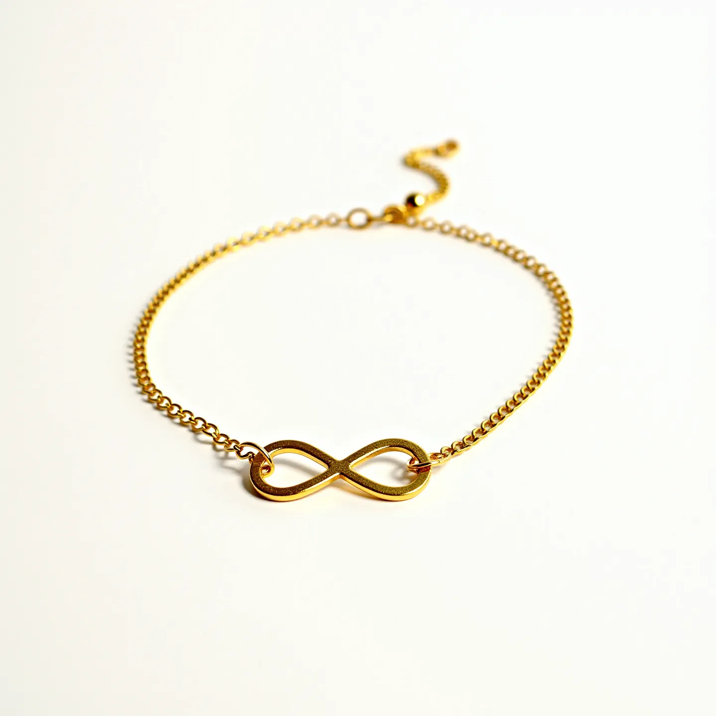 This gold choker necklace features a delicate chain with a central infinity symbol as its focal point. The necklace is crafted from gold, providing a warm and luxurious appearance. The infinity symbol is smoothly integrated within the chain, offering a seamless design. The chain has an adjustable clasp, which allows for customization of the length to ensure a comfortable fit around the neck. The clasp appears to be a lobster-style clasp, which is both secure and easy to use. This necklace exudes elegance and simplicity, making it suitable for various occasions.