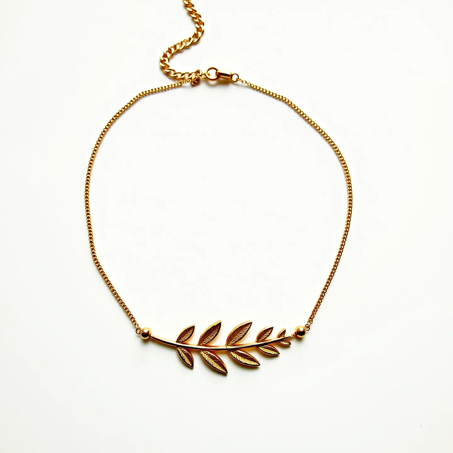 This gold choker necklace features a delicate chain with a prominent leaf motif as its central design element. The gold chain is composed of small, interlinked loops that provide flexibility and a subtle shine. The leaf motif is crafted with fine detailing, giving it a natural and intricate appearance. At the center, the gold setting emphasizes the leaf pattern, making it the focal point of the piece. The necklace is fitted with a simple lobster clasp, offering secure attachment and easy wearability. The overall design is elegant, highlighting gold as the primary material.