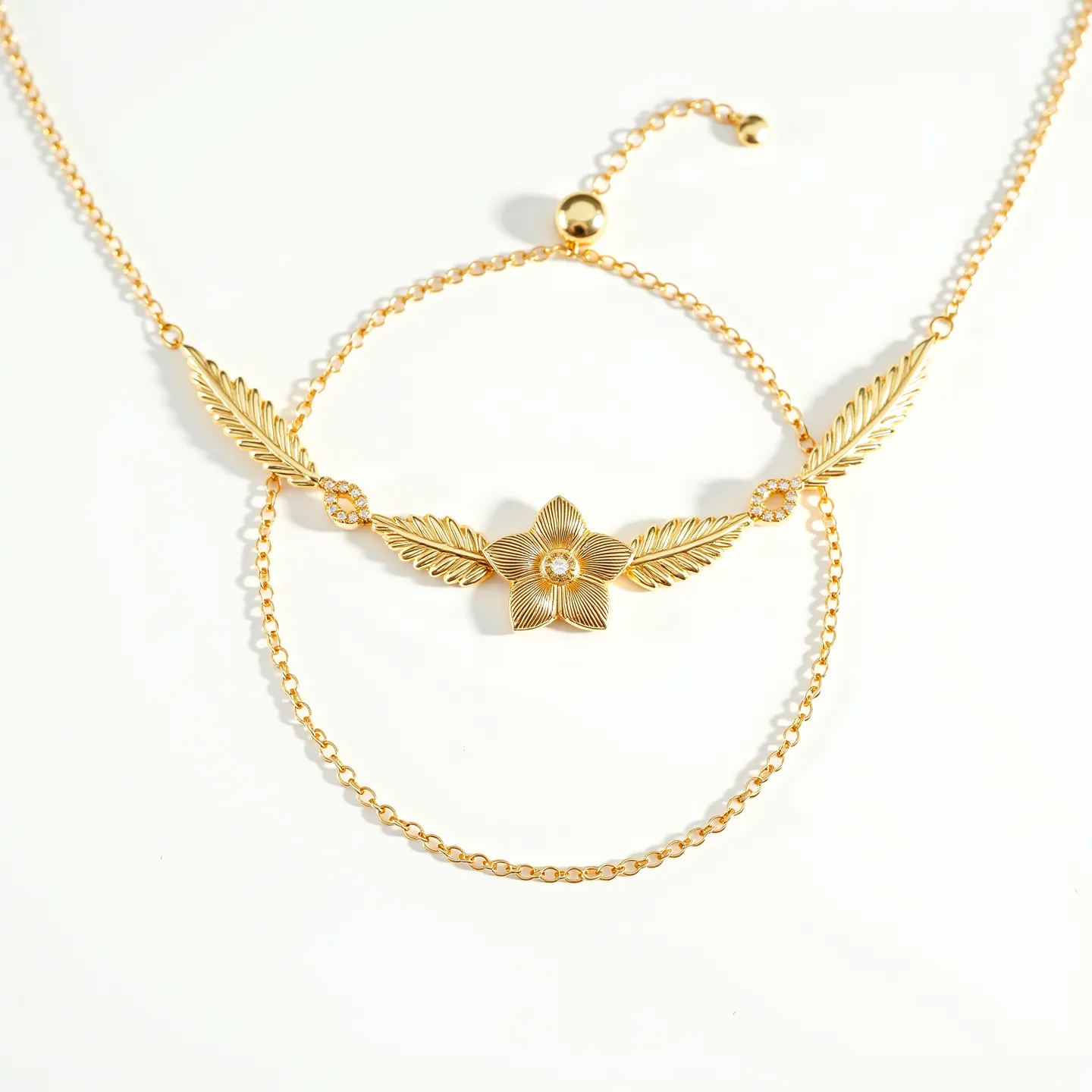 This gold choker necklace features a delicate design with intricate elements crafted in gold. The centerpiece is a charming floral motif, flanked by finely detailed feather-like accents, each contributing to a harmonious aesthetic. The flower's center houses a small, clear gemstone that adds a subtle sparkle to the piece. The necklace is constructed with a fine chain that elegantly supports the decorative elements. It fastens with an adjustable clasp, allowing for a comfortable and customizable fit.